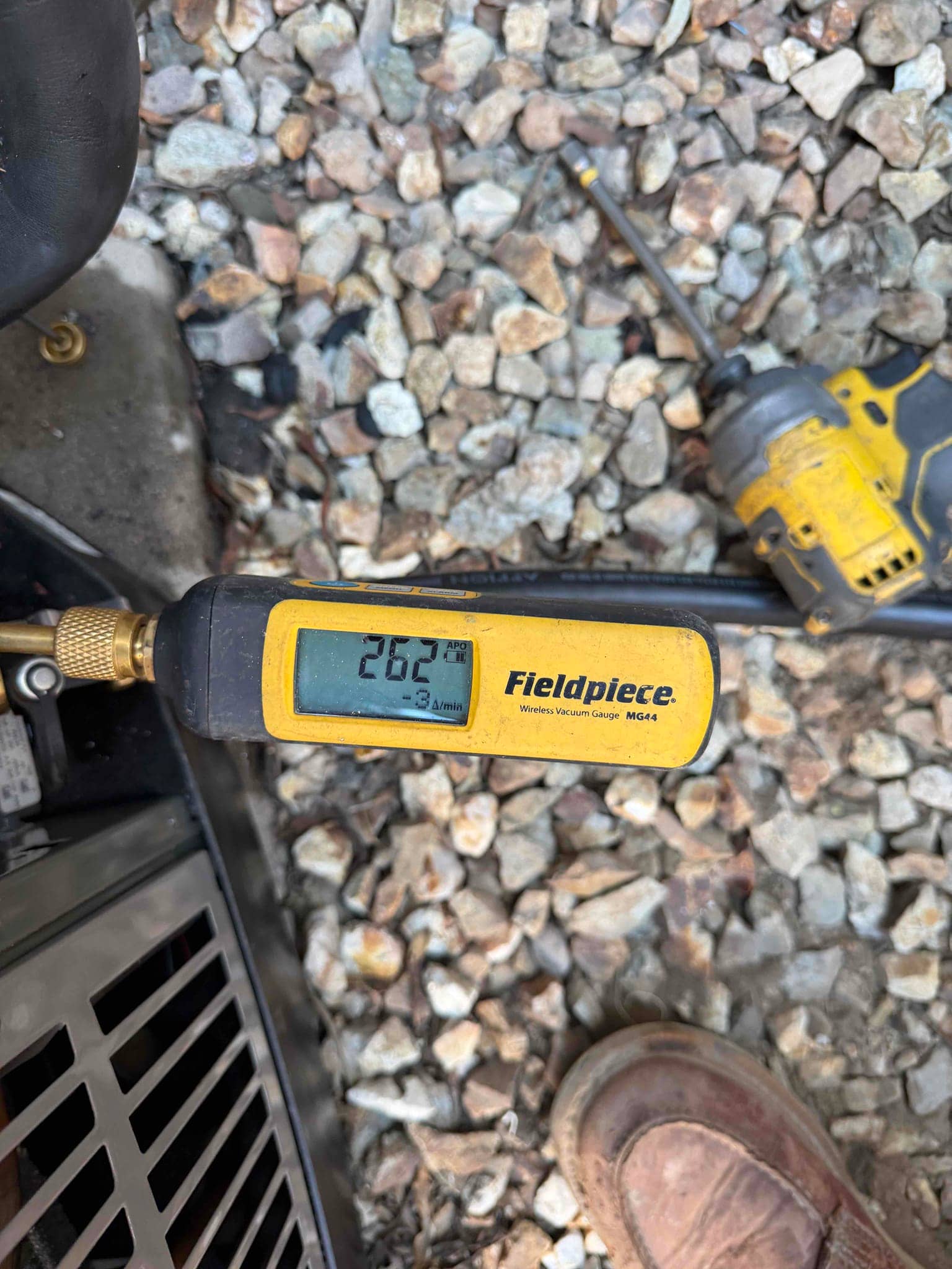 Wireless vacuum gauge connected at the outdoor unit reads 262 microns during the evacuation phase before refrigerant charging.