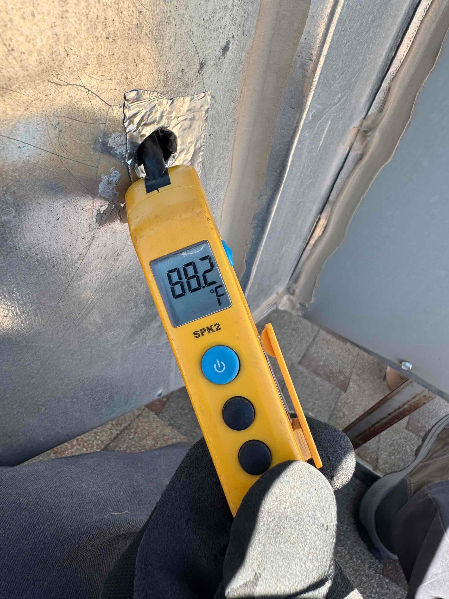 Digital thermometer measures 88.2 °F on a metal surface with the probe held in place by tape.