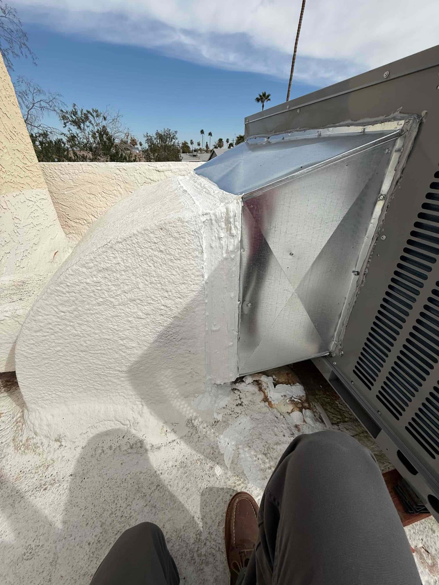 New packaged unit curb adapter and sealed duct transition installed on the rooftop, with mastic and flashing applied at all seams.