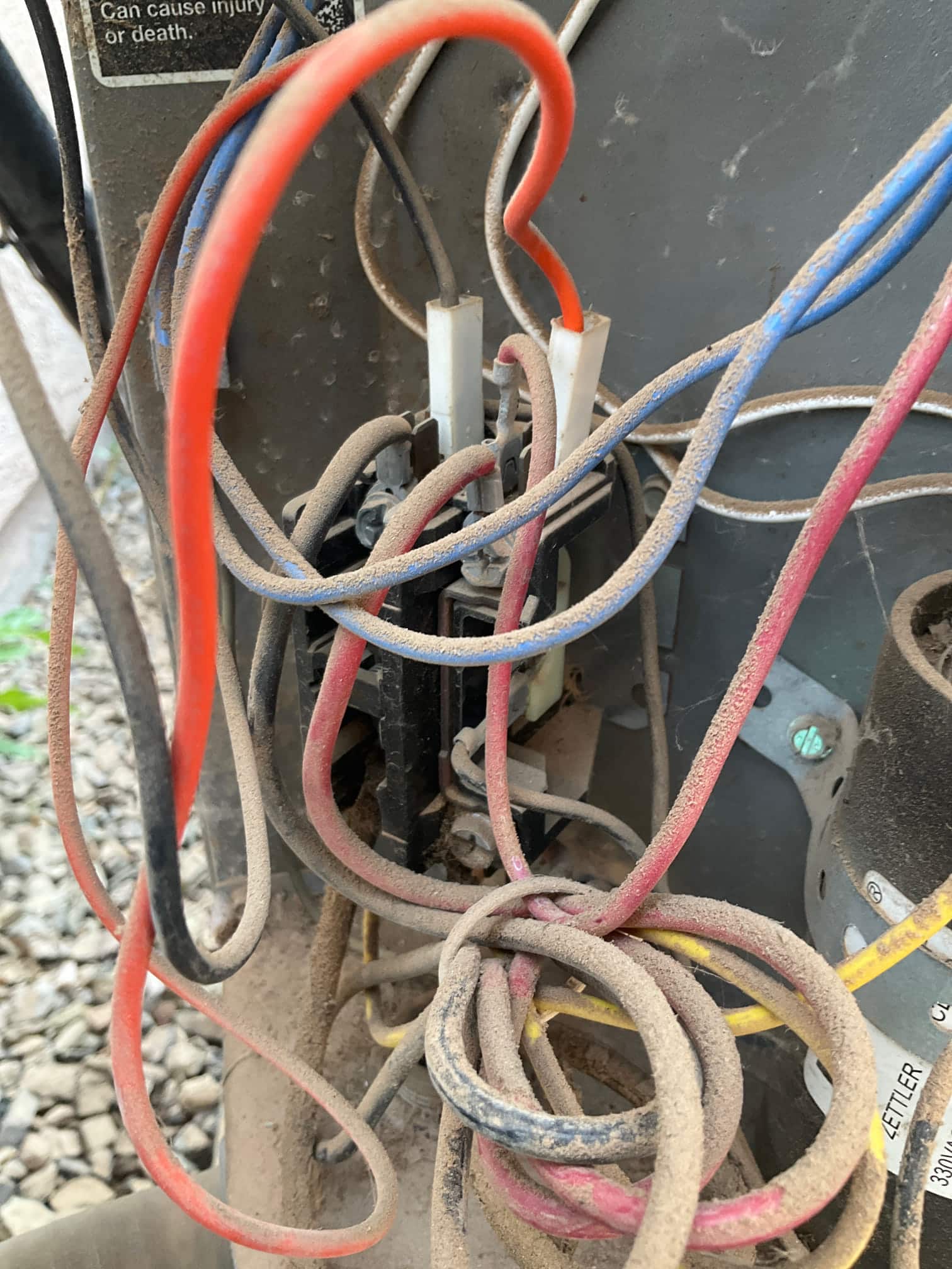Contactor with multiple connected control and power wires inside outdoor condenser compartment, all surfaces coated with dust.