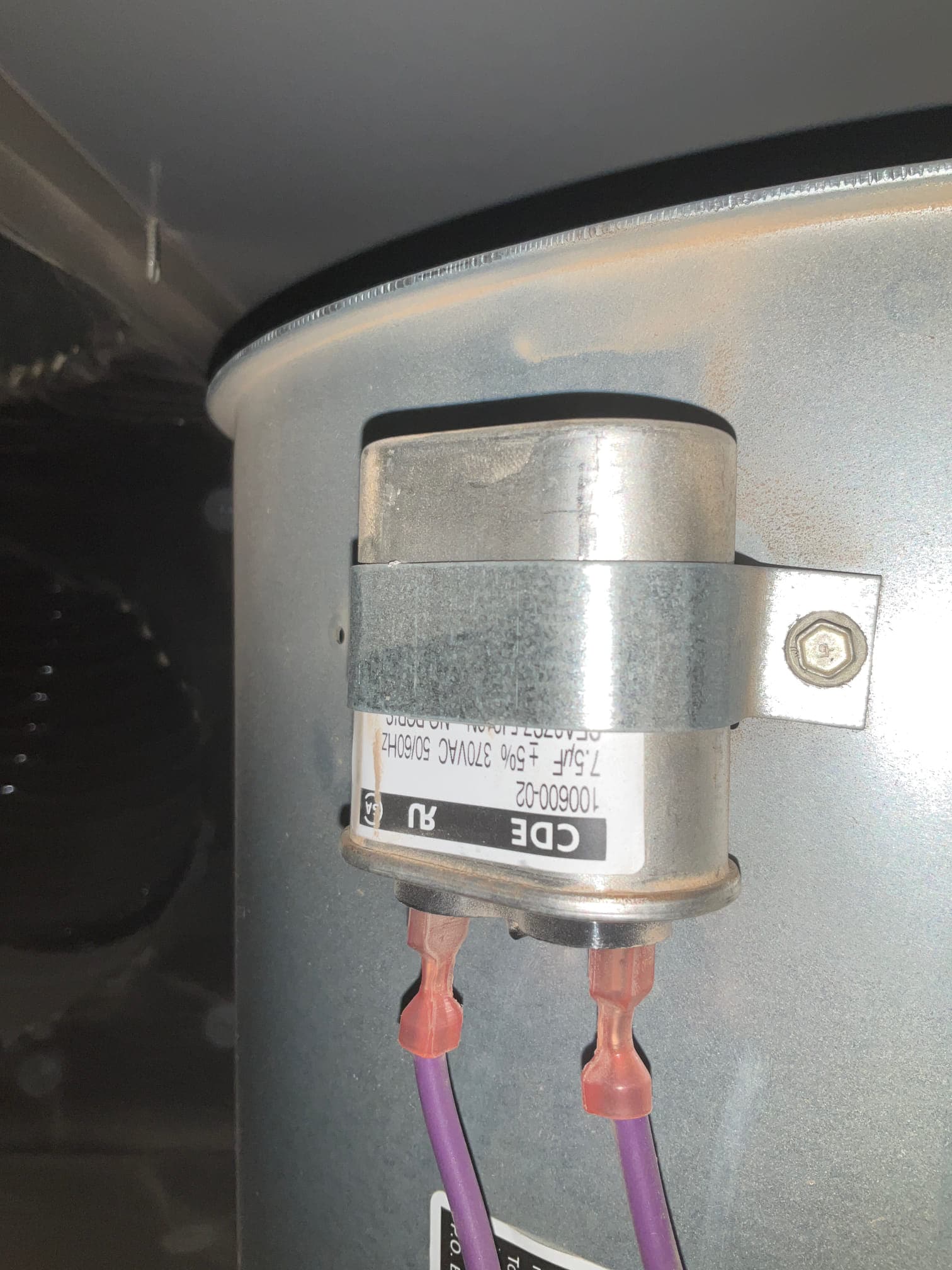 Run capacitor mounted with a metal strap on a cylindrical housing, labeled 7.5 μF ±5% 370VAC 60/50Hz, with purple leads connected.