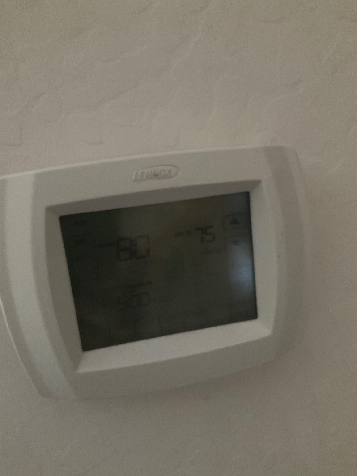 Wall-mounted digital thermostat with backlit display showing 80 room temperature and 75 cooling setpoint.