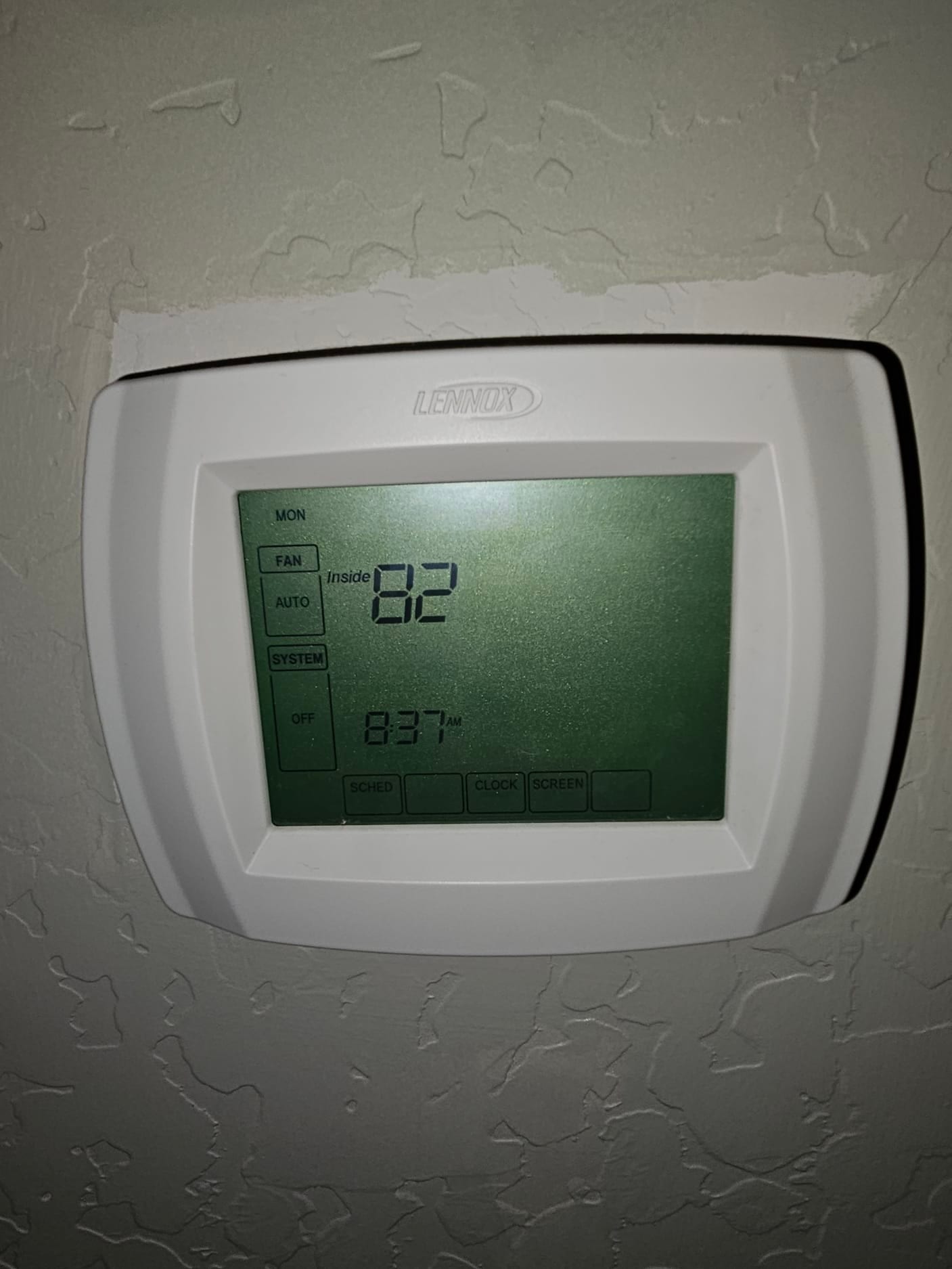 Wall-mounted thermostat display shows inside temperature 82, time 8:37 AM, and system set to auto mode.