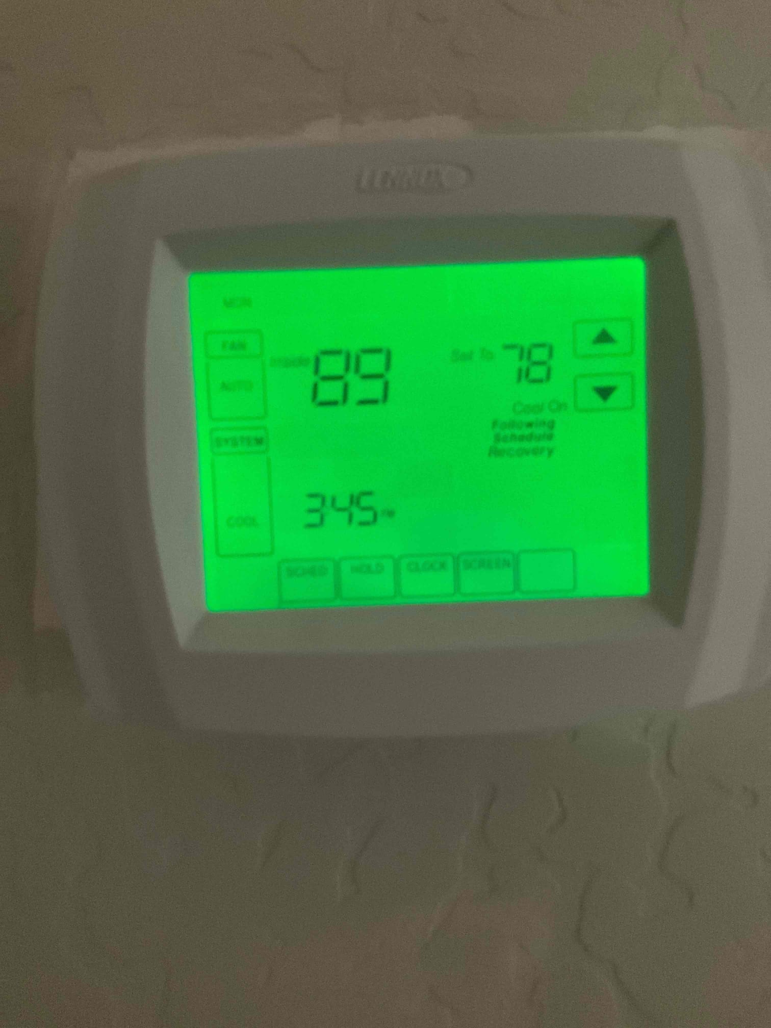 Wall-mounted thermostat with green backlight shows inside 89 and setpoint 78 with cooling mode selected.
