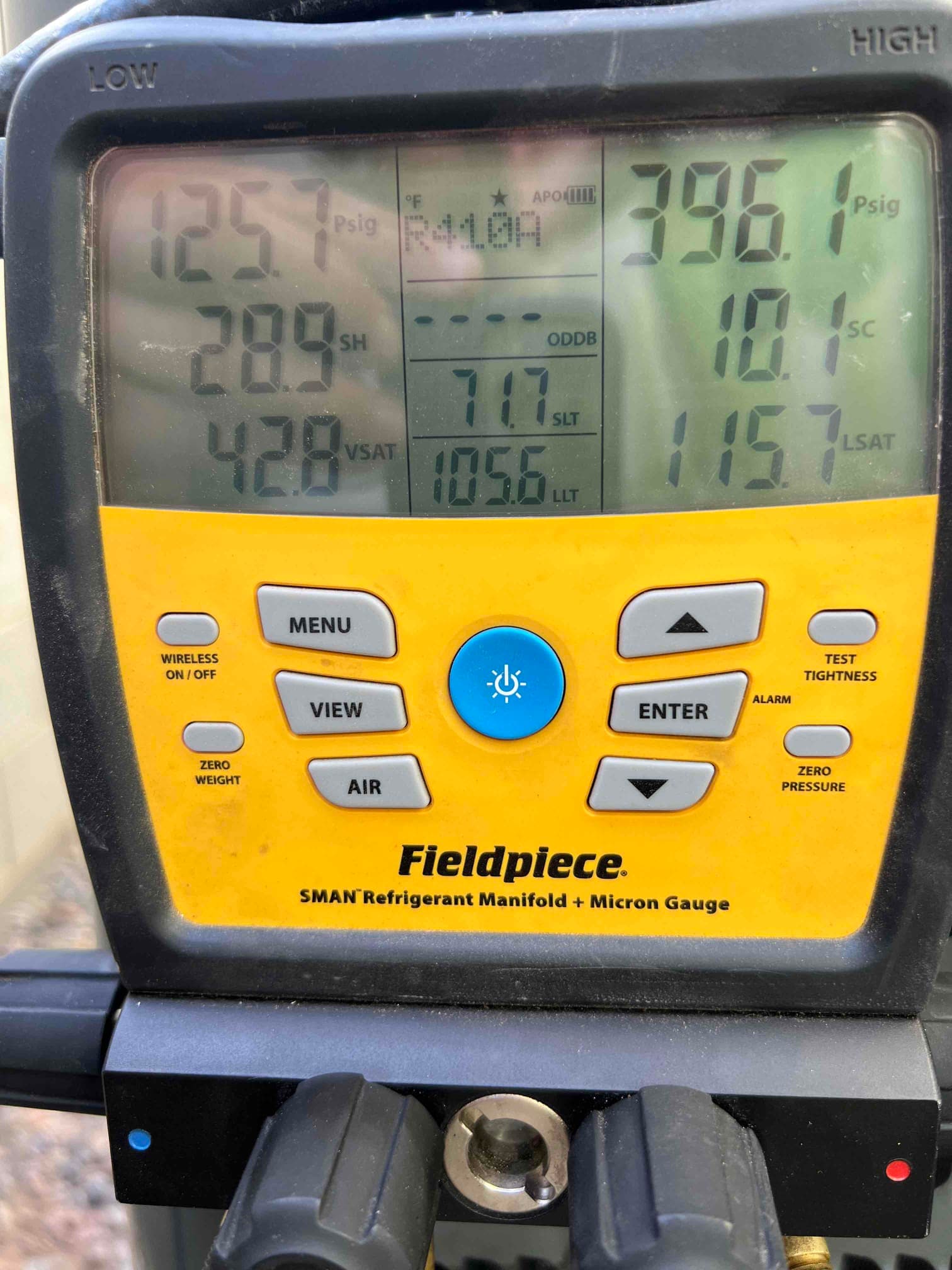 Digital manifold shows operating pressures with low side at 125.7 PSI and high side at 396.1 PSI during system commissioning.