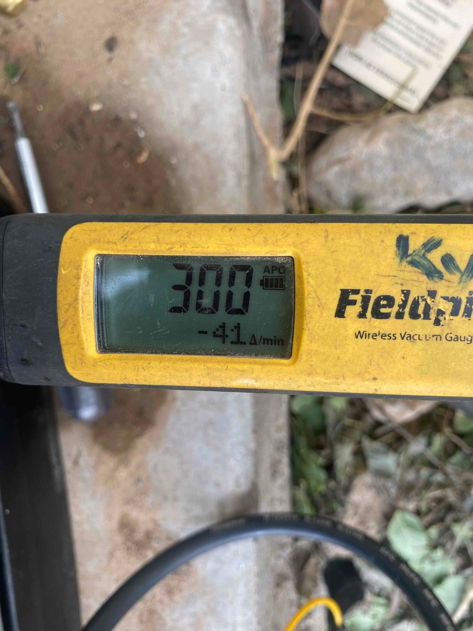 Digital micron gauge displays 300 microns during system evacuation, confirming a deep vacuum before releasing refrigerant charge.