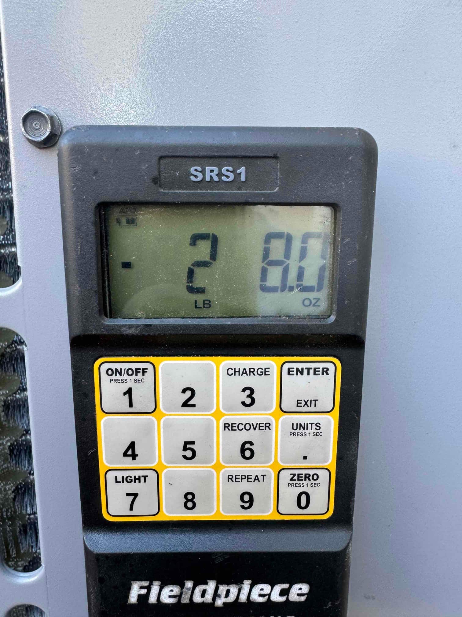 Digital refrigerant scale shows 2 pounds 8 ounces during charging of the newly installed system.