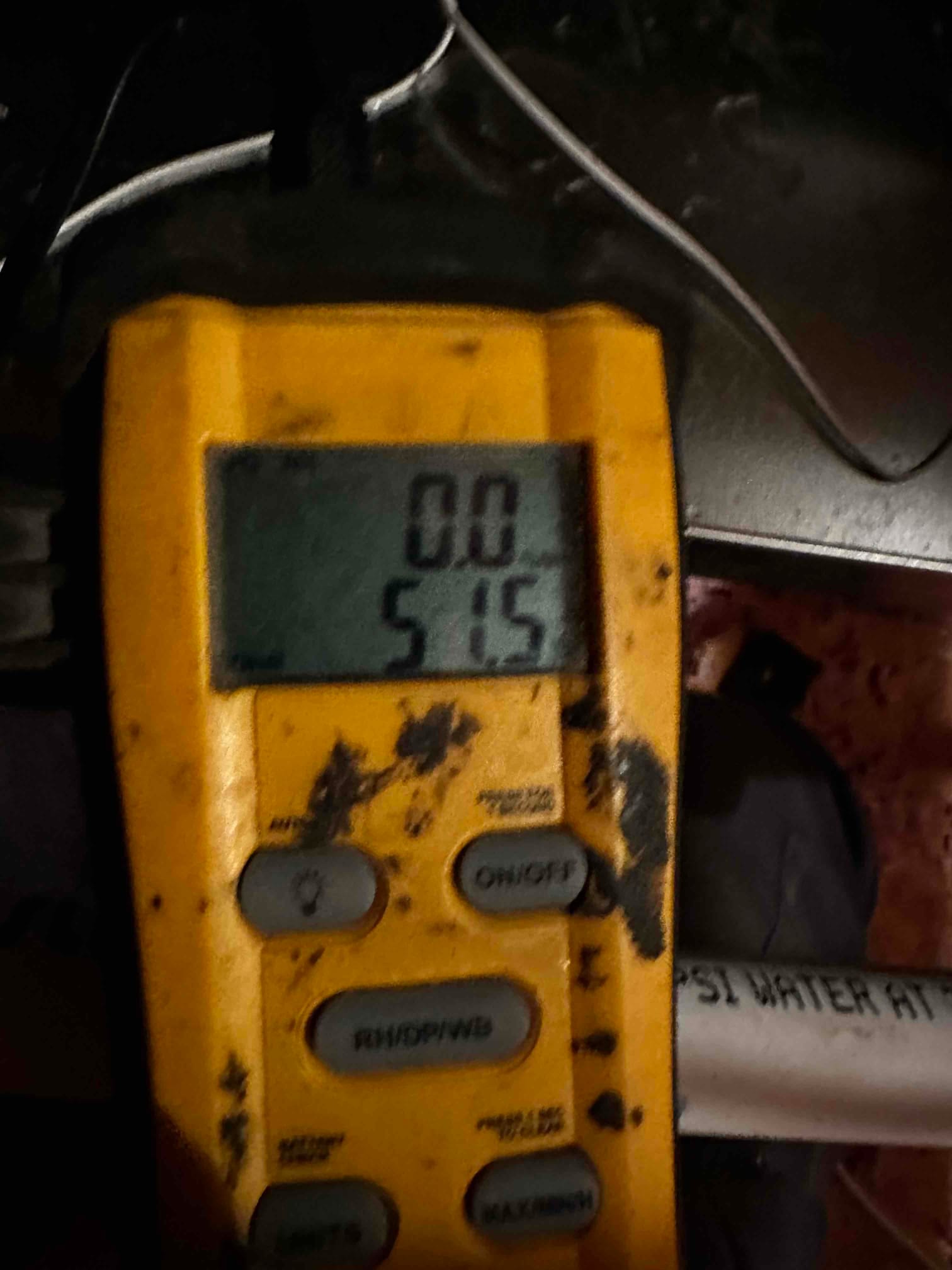 Digital thermometer shows a 51.5°F reading during air temperature check at the duct for system commissioning.