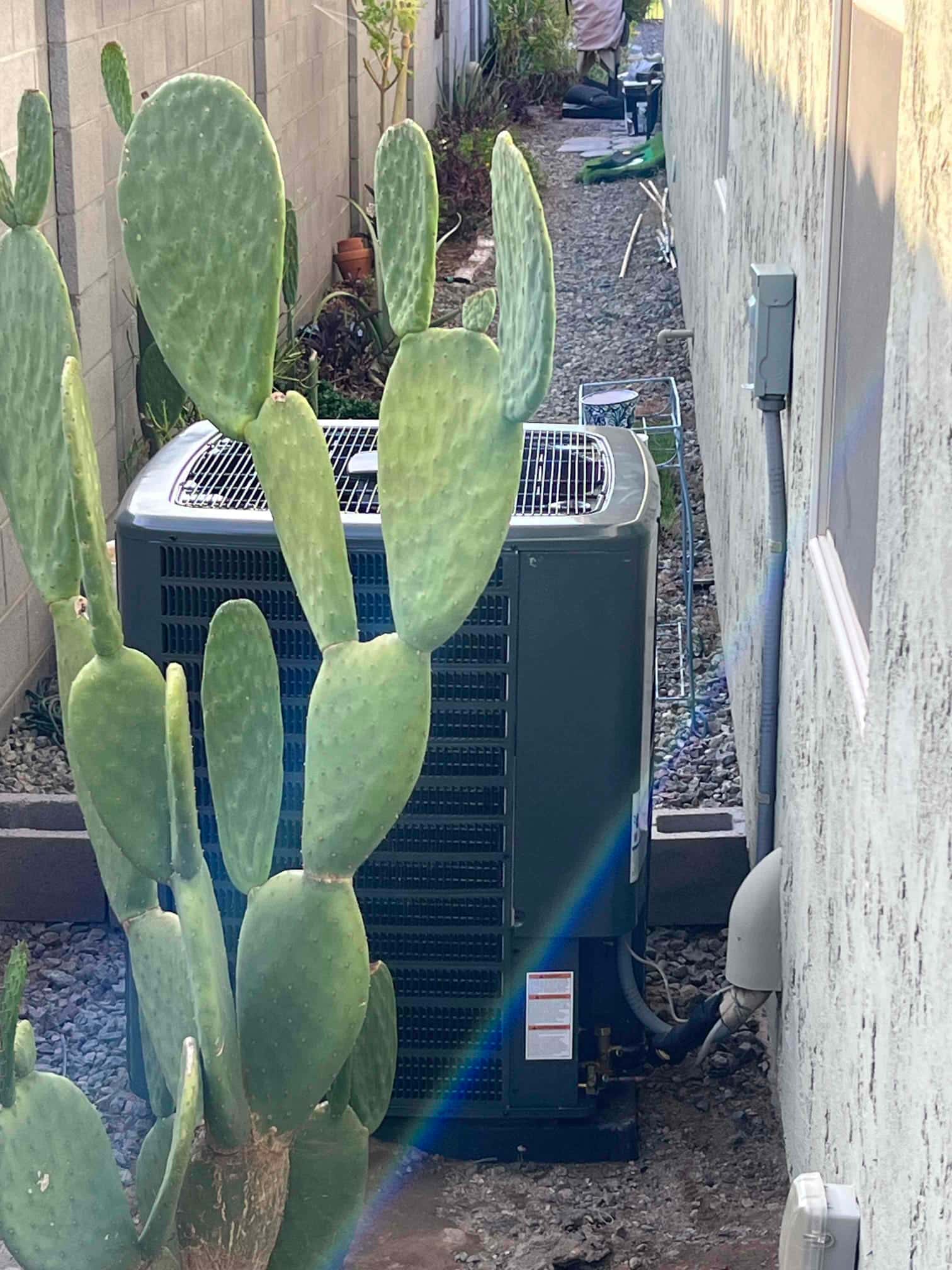 New outdoor heat pump condenser set on a level pad with insulated line set and nearby electrical disconnect.