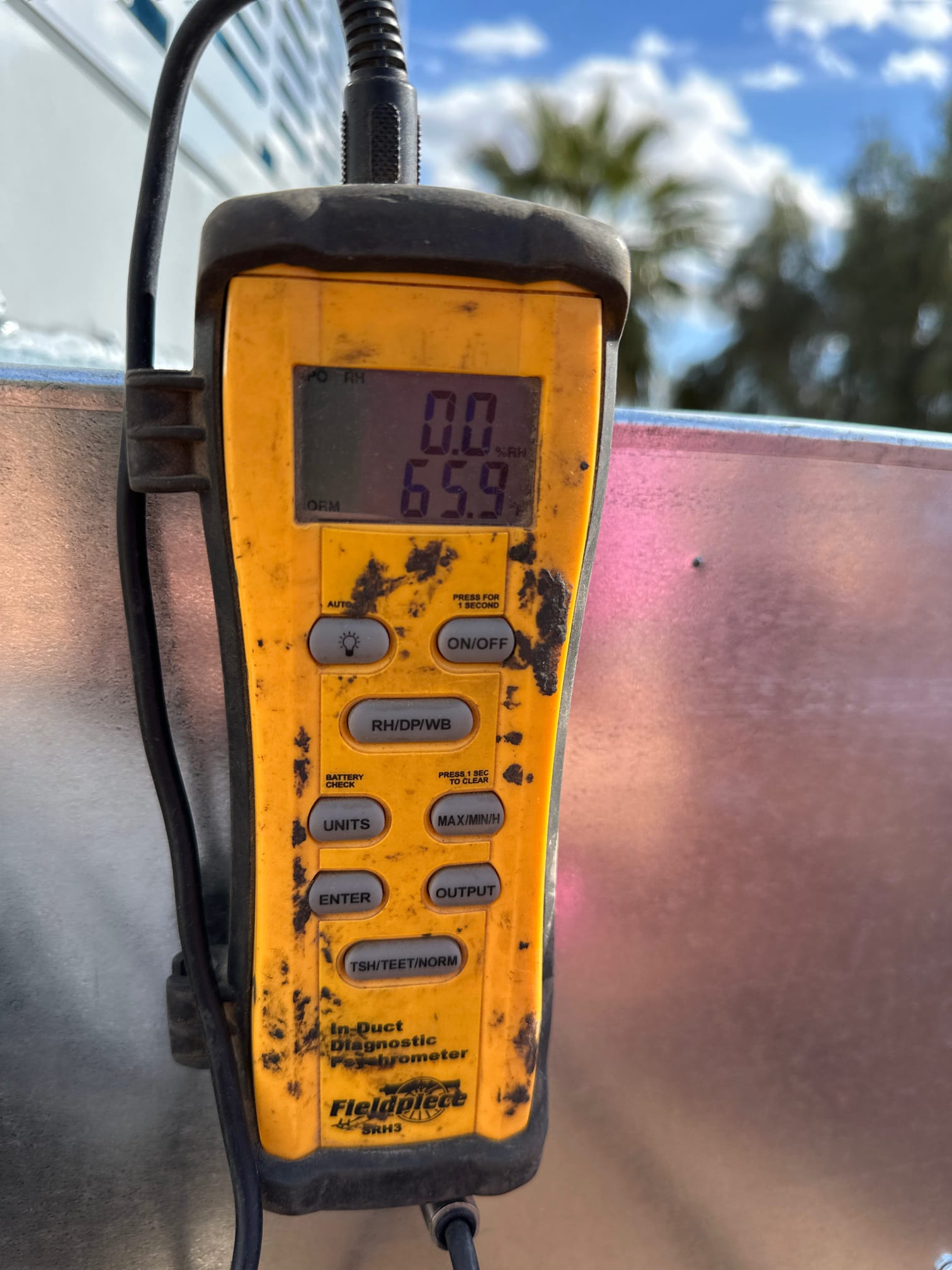 Digital in-duct thermometer displays 65.9 degrees Fahrenheit during airflow temperature check on the newly installed system.