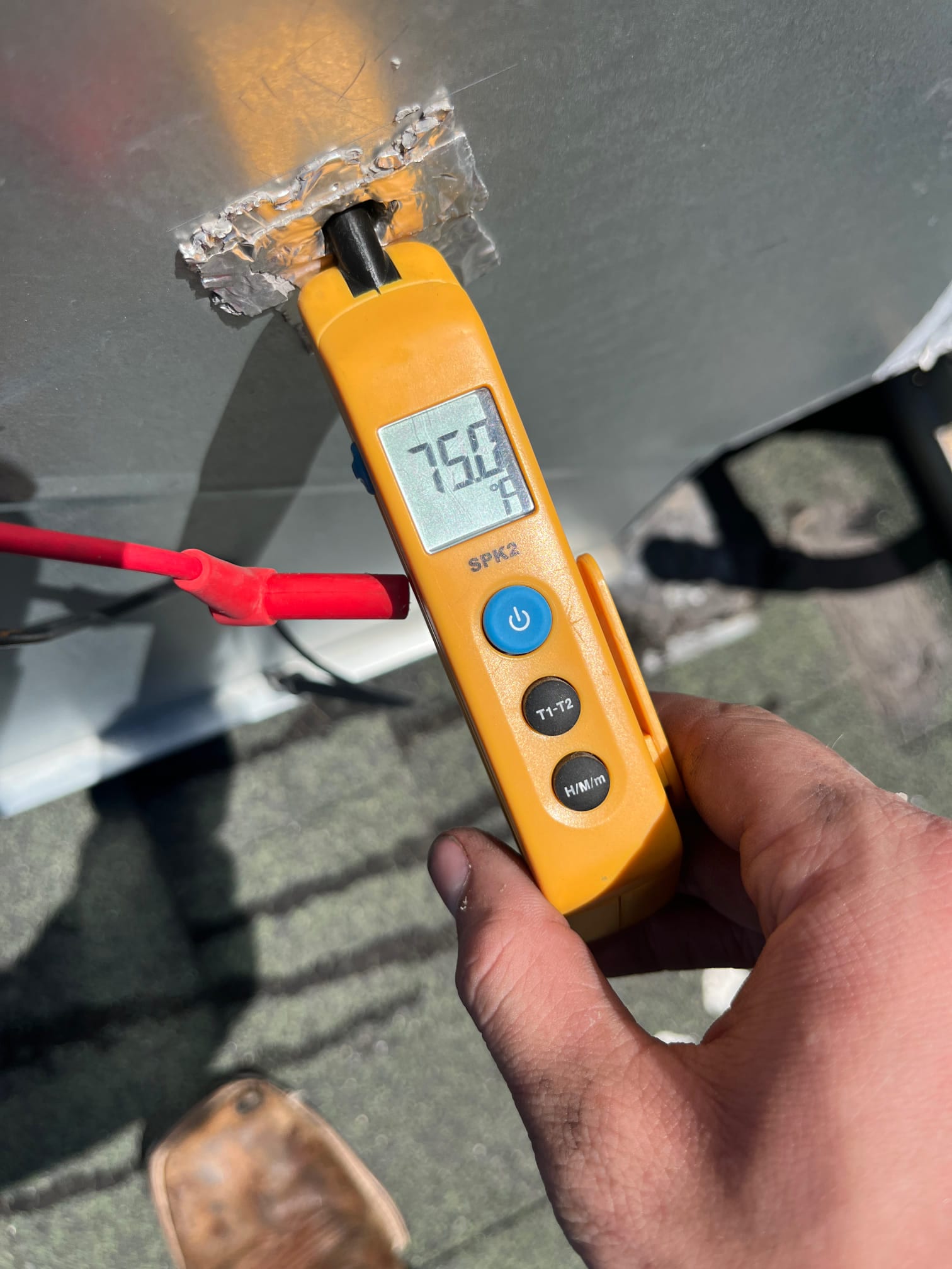 Digital thermometer shows 75.0 °F surface temperature at the probe contact point on the metal housing.