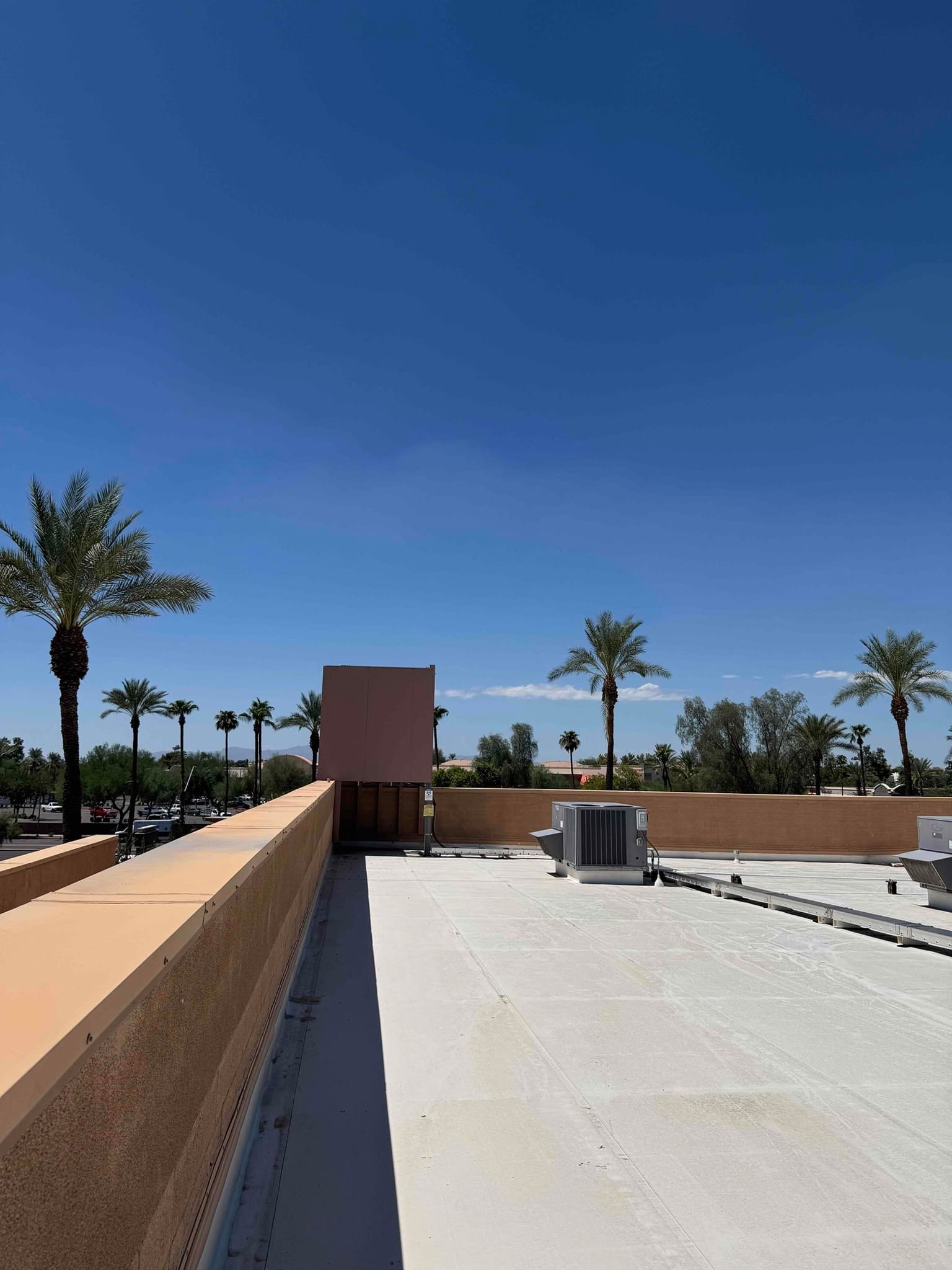 Rooftop view of commercial HVAC equipment, including packaged units and ductwork, under clear daytime conditions.