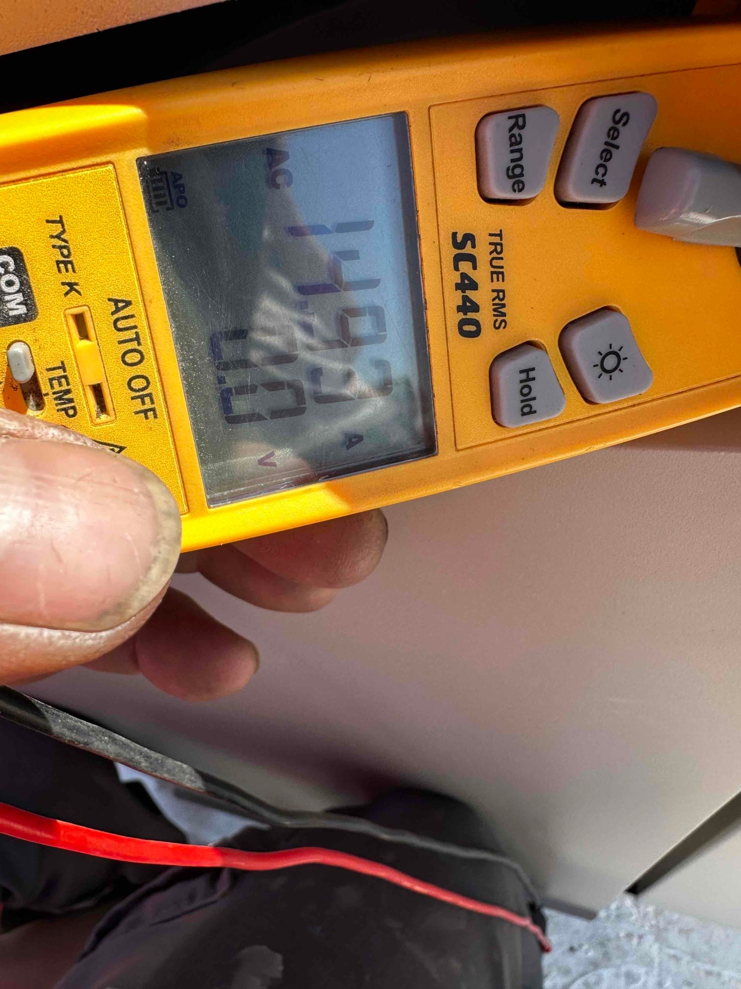 Digital clamp meter displays 14.93 A AC during electrical commissioning on the HVAC installation.