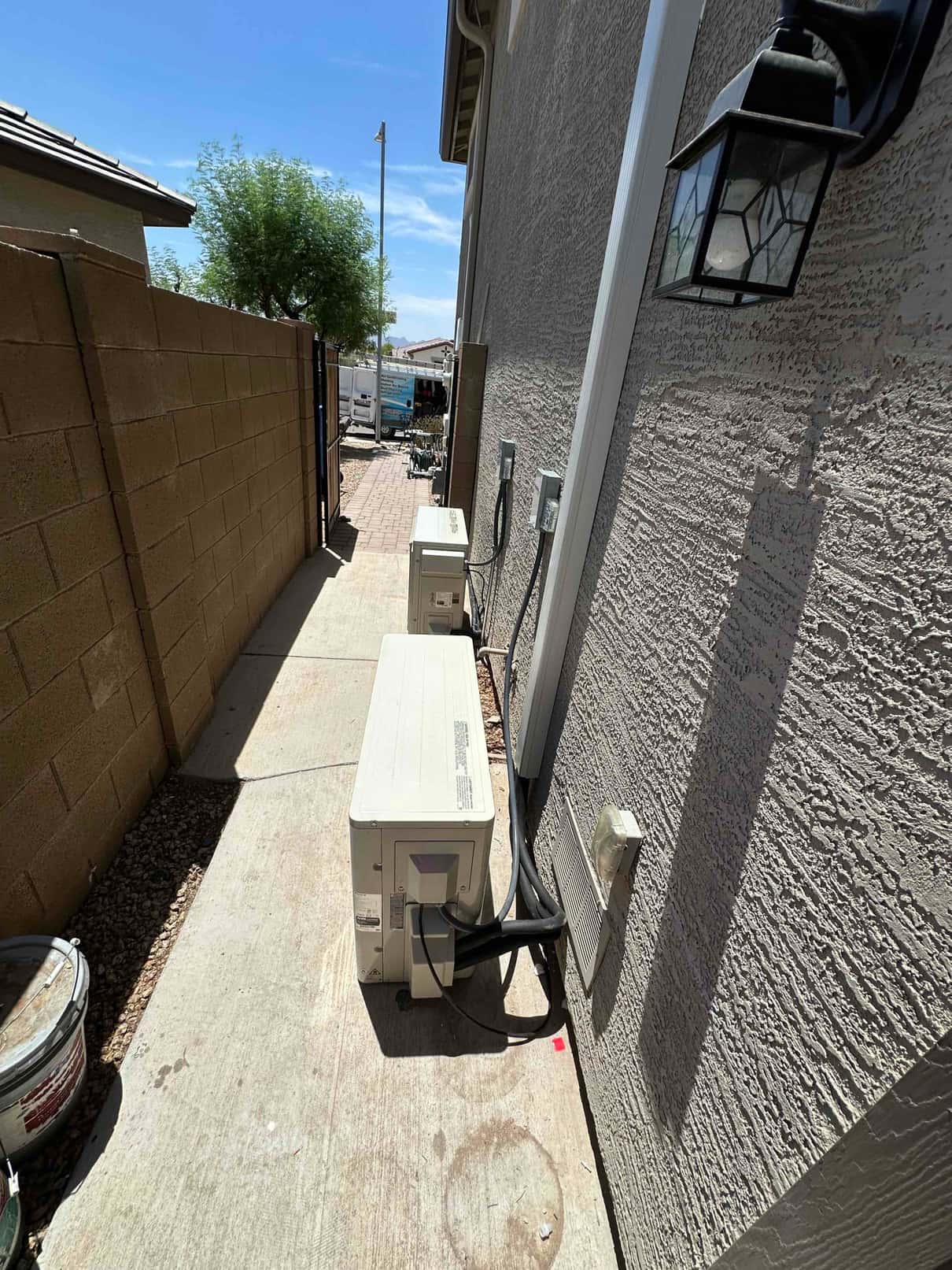 Two new mini-split outdoor condensers set along the side yard with insulated line sets and dedicated disconnects.