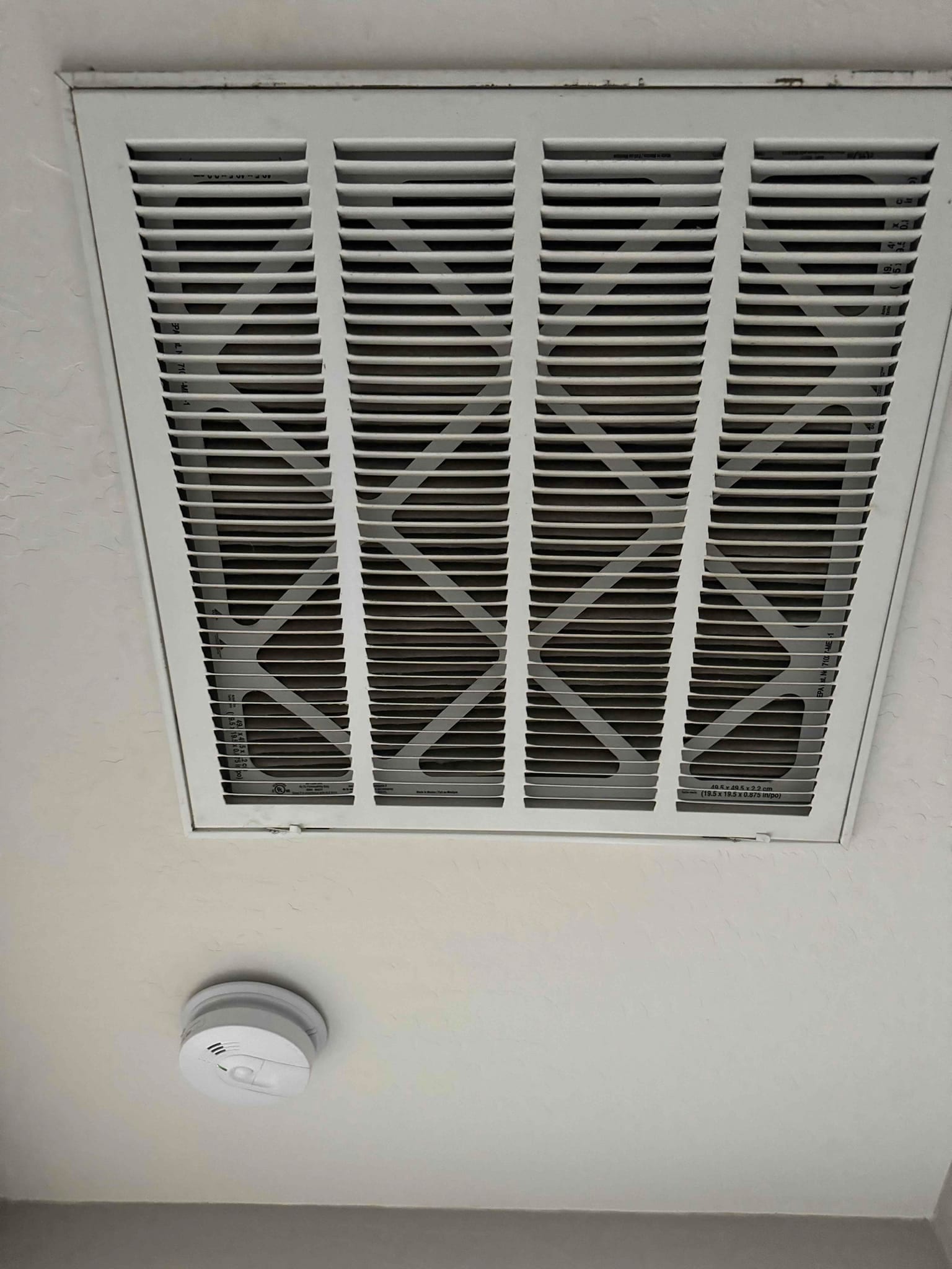 Ceiling return air grille with a pleated air filter installed behind the louvers.