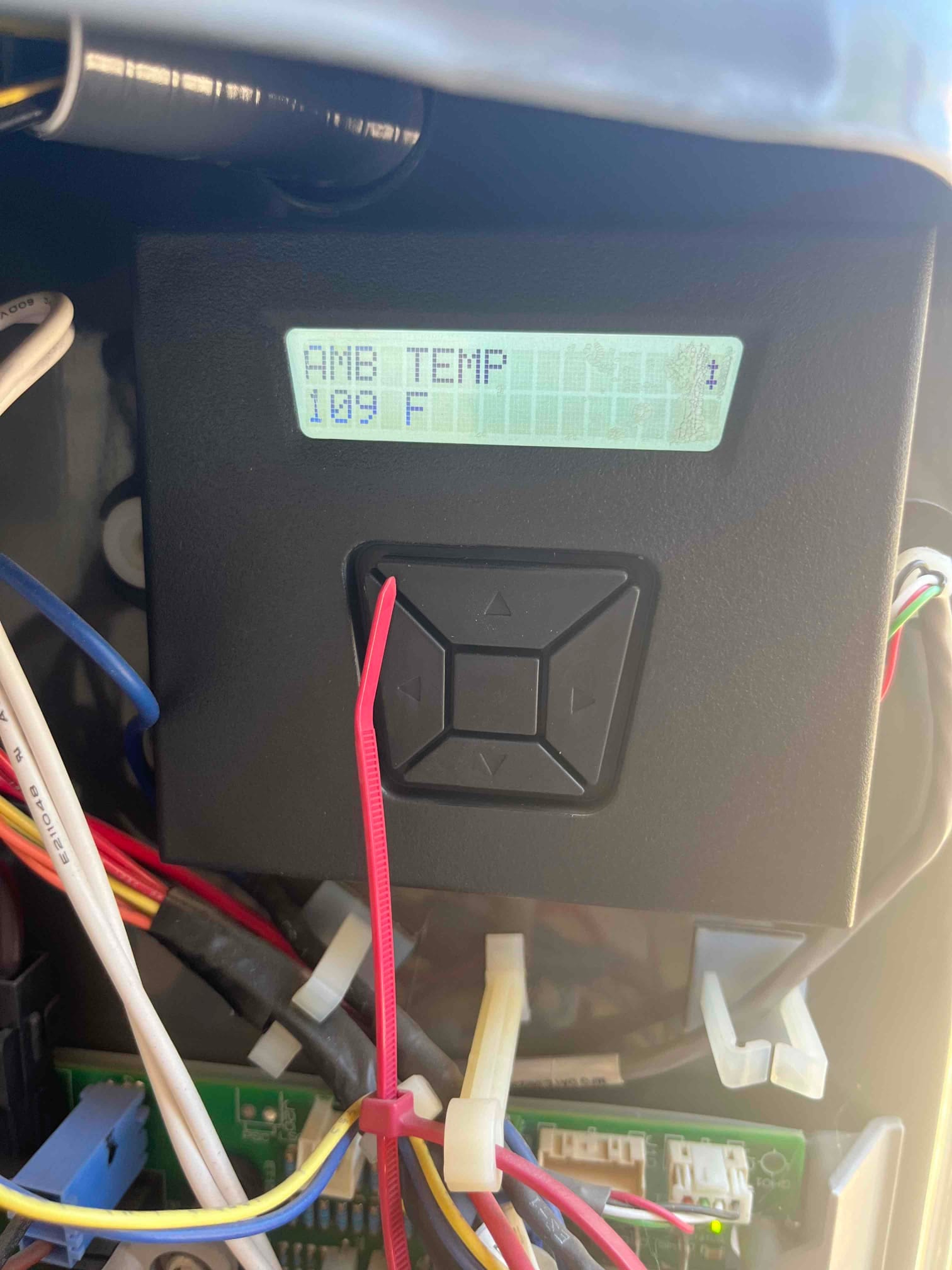 Control module display inside outdoor unit shows AMB TEMP and 109 F, with surrounding control wiring and harness ties.
