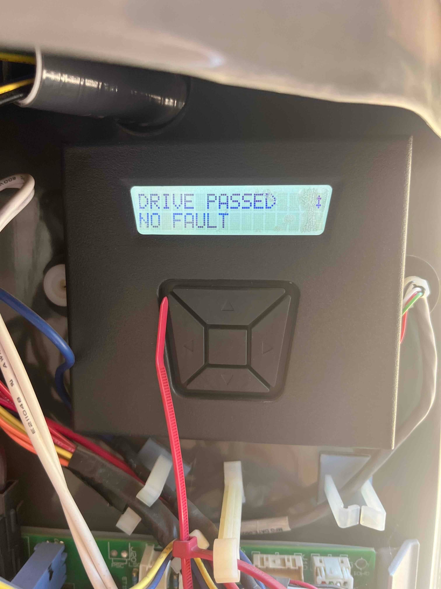 Control module inside HVAC unit with screen displaying 'DRIVE PASSED NO FAULT' and wiring harnesses connected.