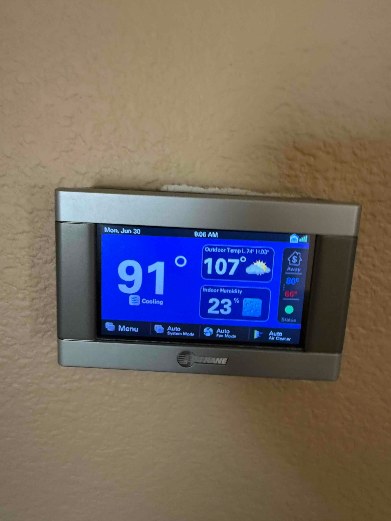 Thermostat display shows indoor temperature 91°, outdoor temperature 107°, and indoor humidity 23% while in cooling mode.