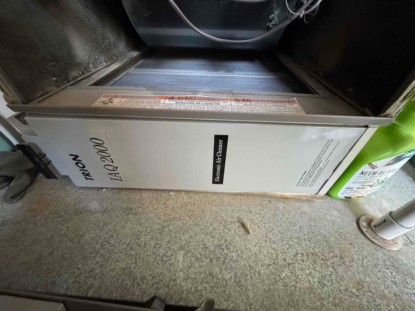 Electronic air cleaner cabinet installed in the air handler return section, with access panel closed and warning label visible.