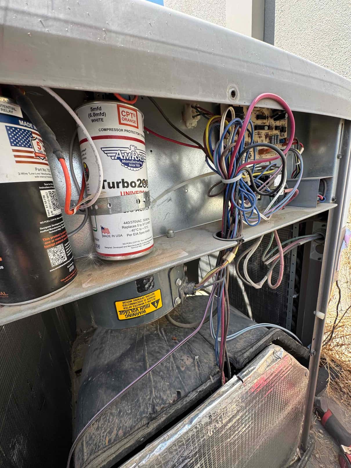 Open HVAC compartment shows 'Turbo 200' run capacitor labeled 5 mfd (6.0 mfd) and bundled wiring.