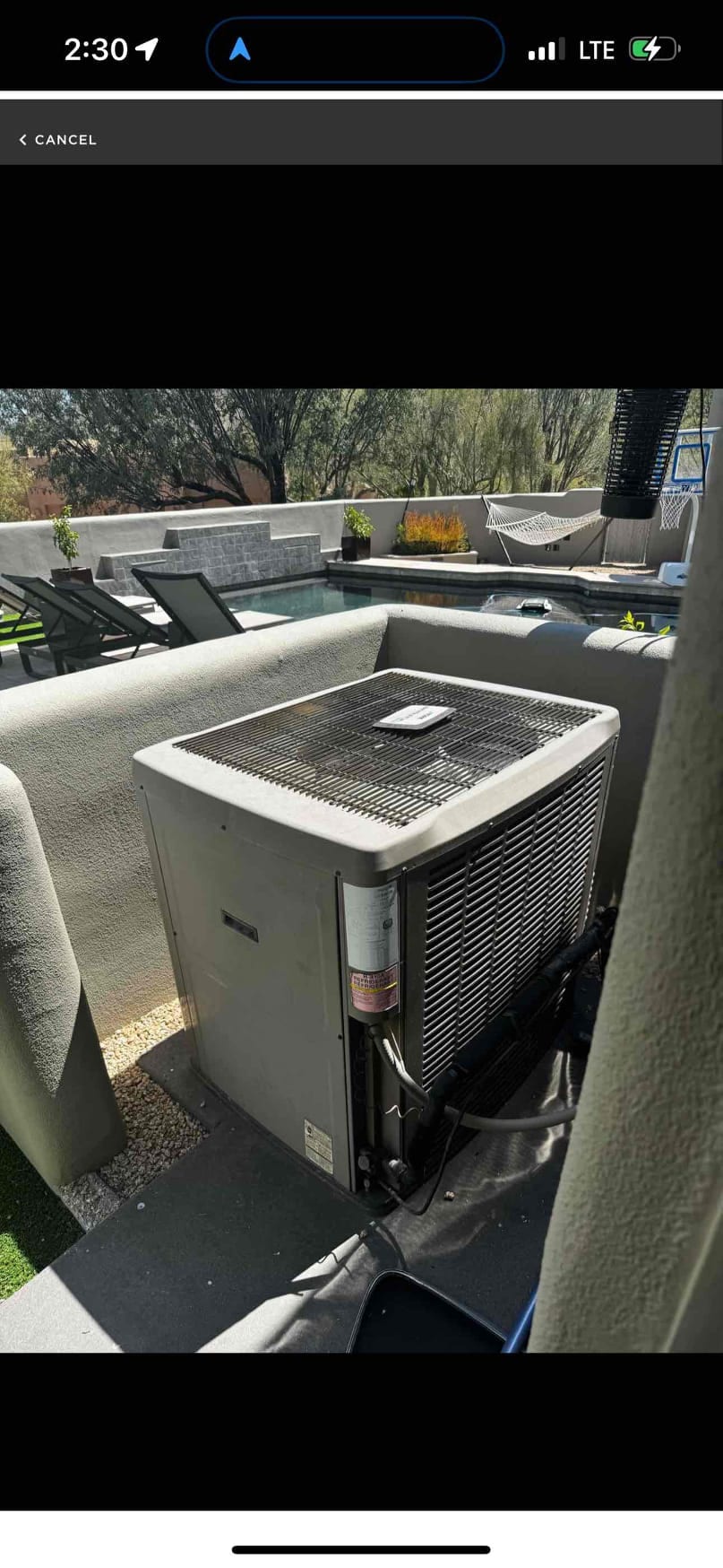 Outdoor air-conditioning condenser sits on a rooftop patio, with refrigerant lines and fan grille visible.
