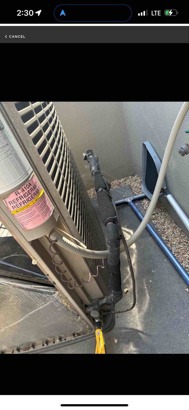 Outdoor condenser with R-410A label, insulated refrigerant lines, and service valve access near the base.