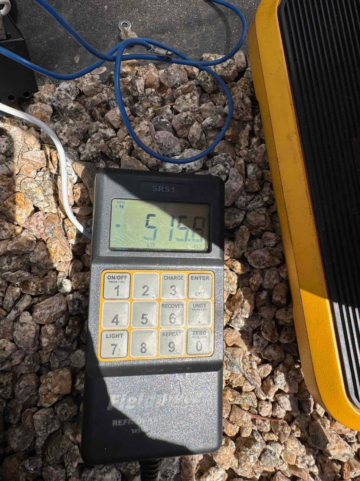 Refrigerant scale photographed during the service visit; no numerical reading is transcribed.