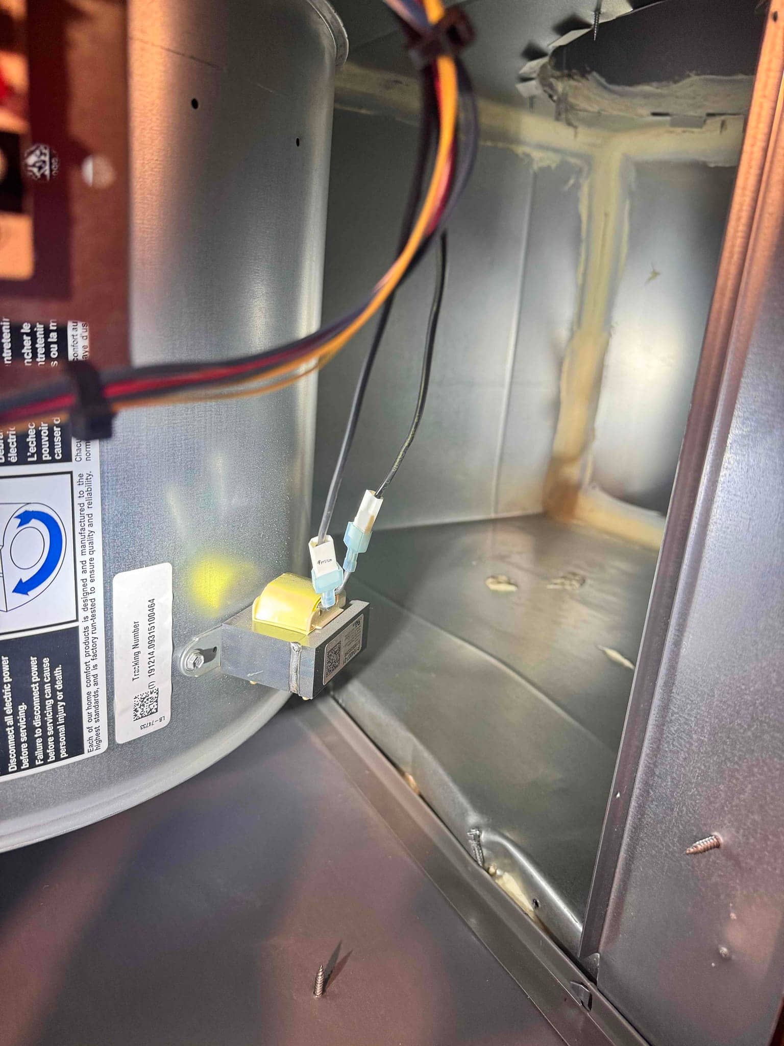 Air handler cabinet interior showing a small mounted electrical switch with two spade-connected wires near the blower.