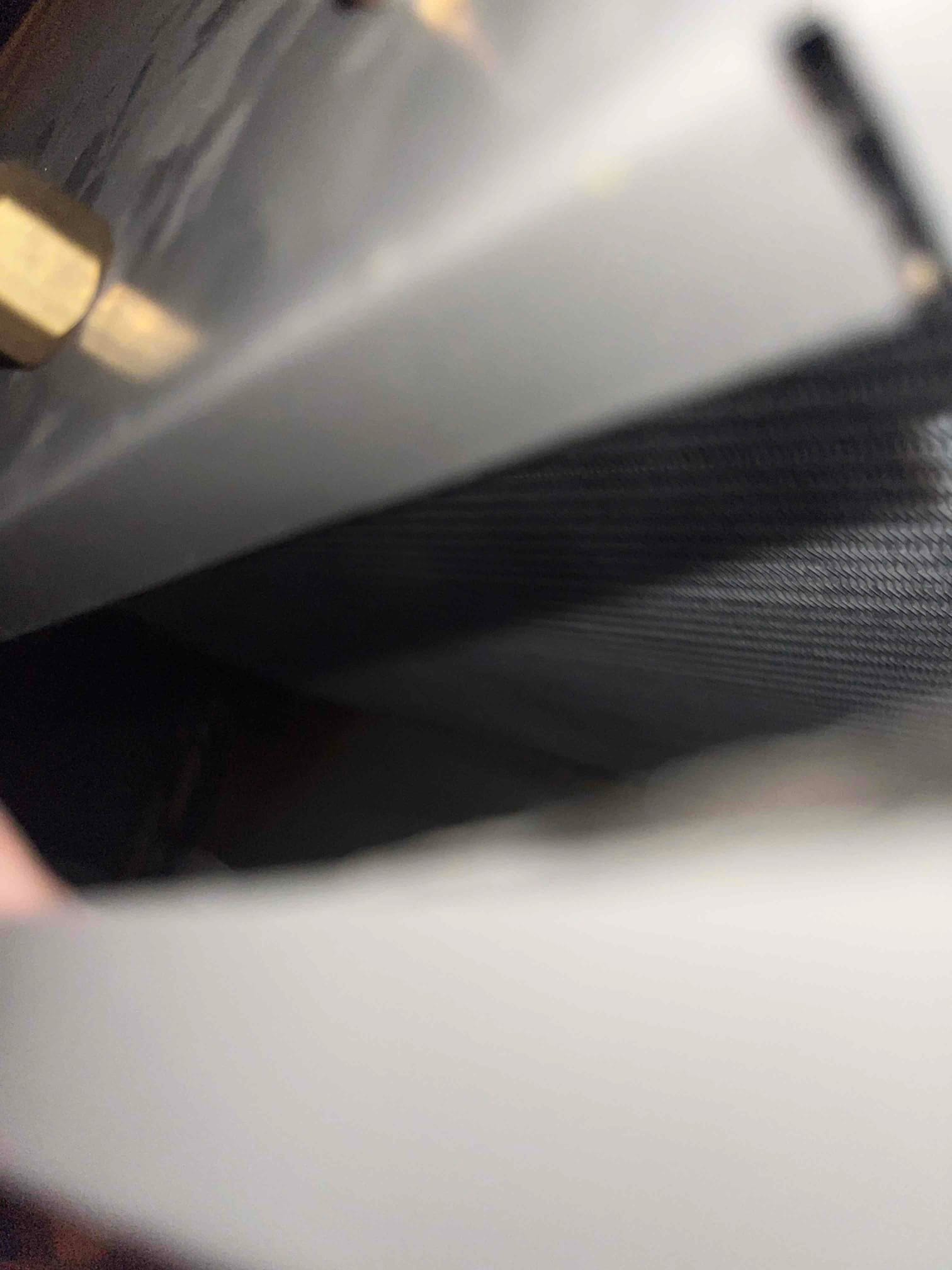 Close-up of brass refrigerant fitting and finned coil surface on HVAC equipment.