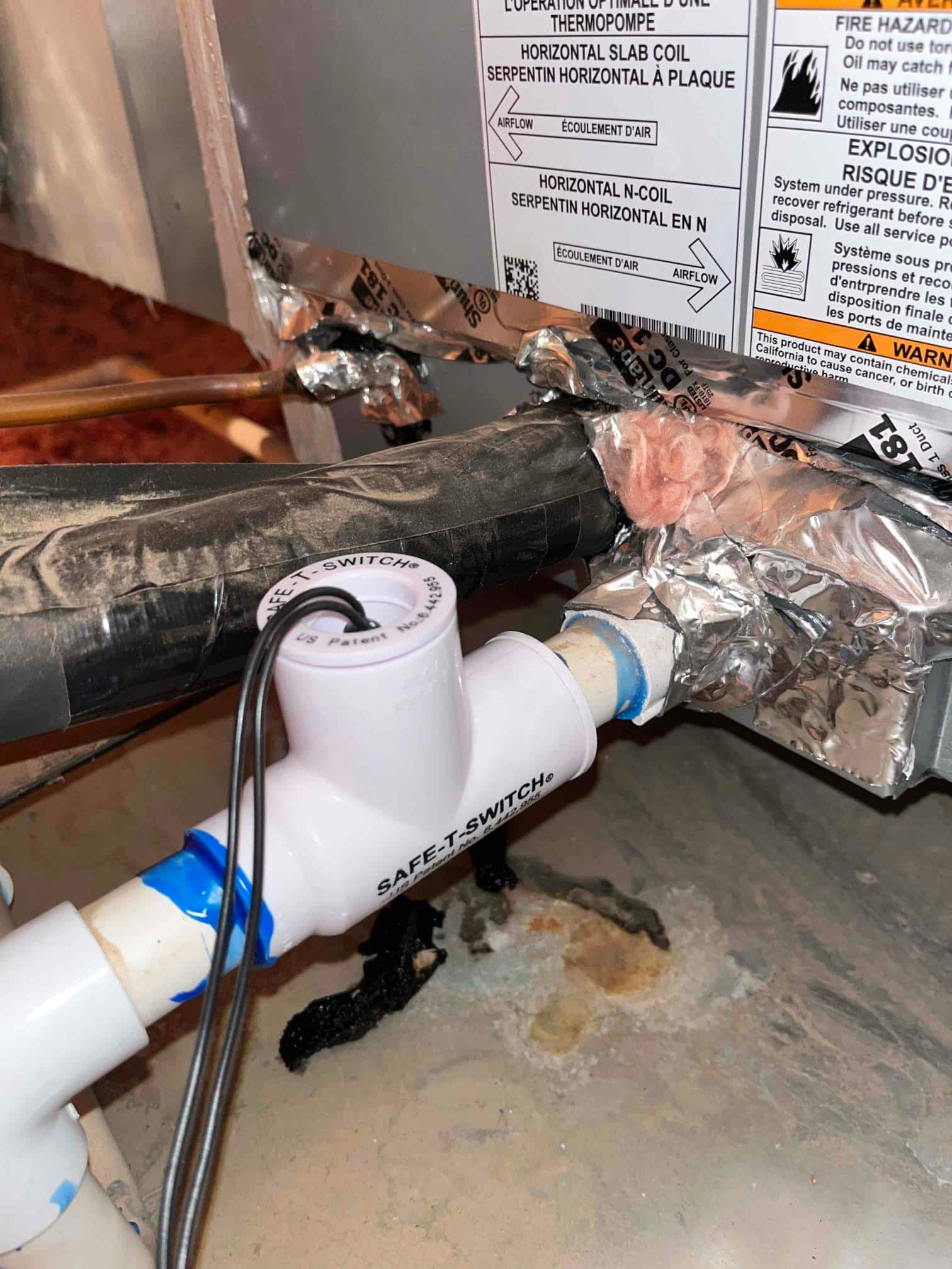 Condensate drain line with SAFE-T-SWITCH float switch installed at the air handler, with insulated suction line and foil-taped cabinet.