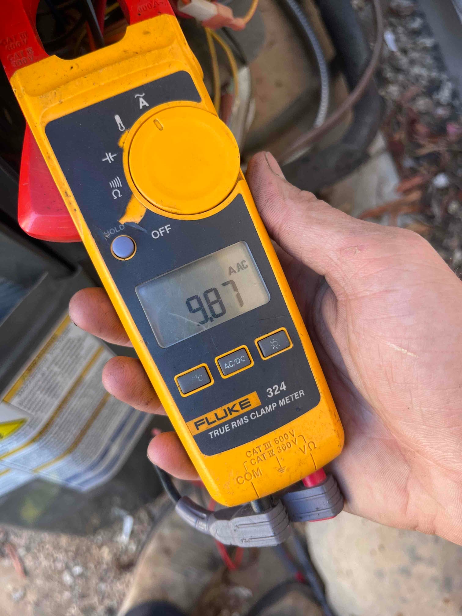 Diagnostic instrument display shows 9.87 A.