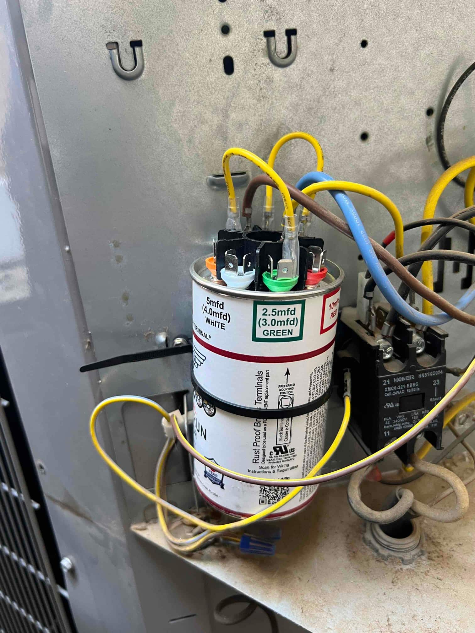 Multi-tap run capacitor secured with zip ties, color-coded terminals connected. Label shows 5 mfd WHITE and 2.5 mfd GREEN.