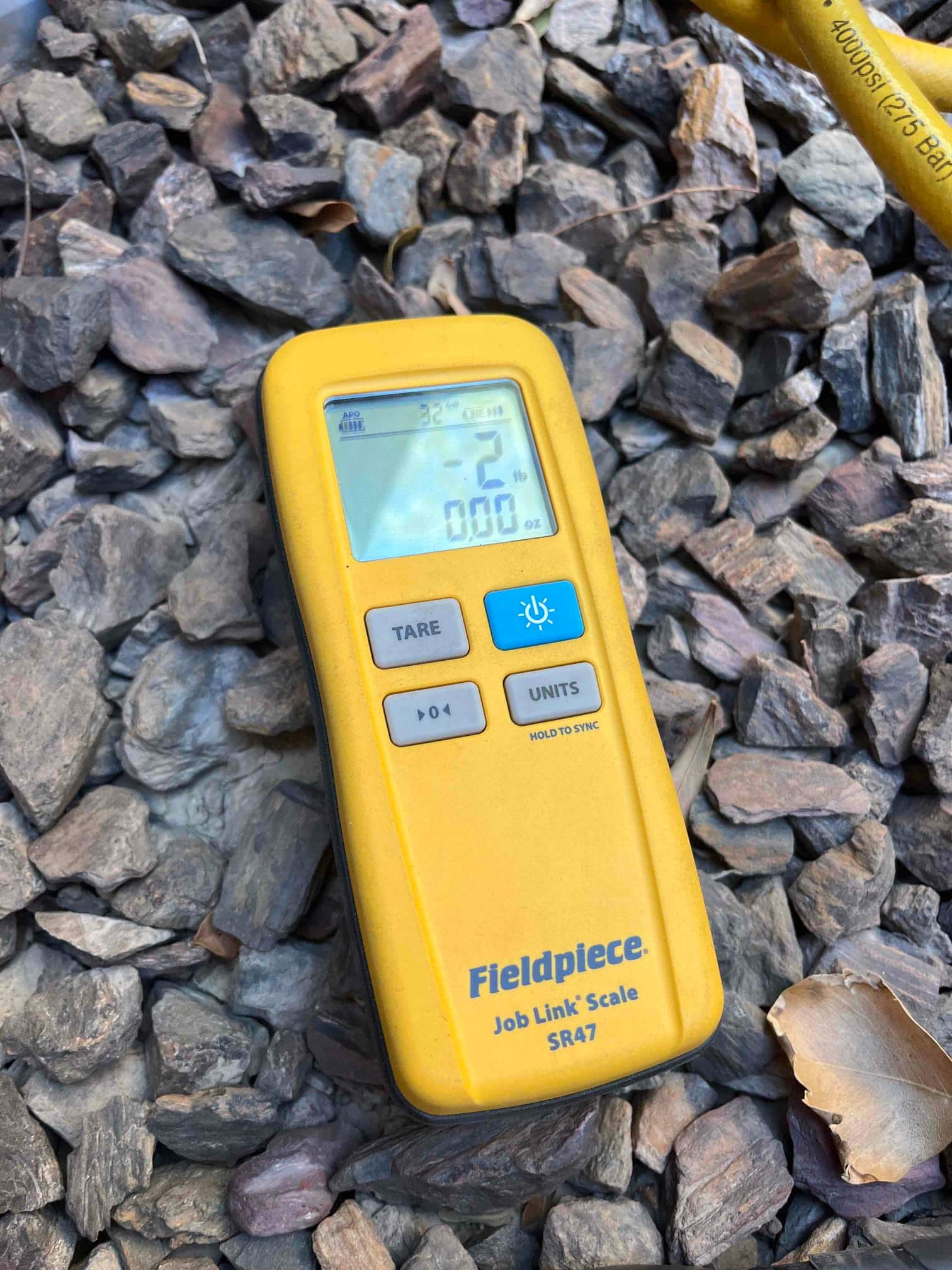 Refrigerant scale photographed during the service visit; no numerical reading is transcribed.