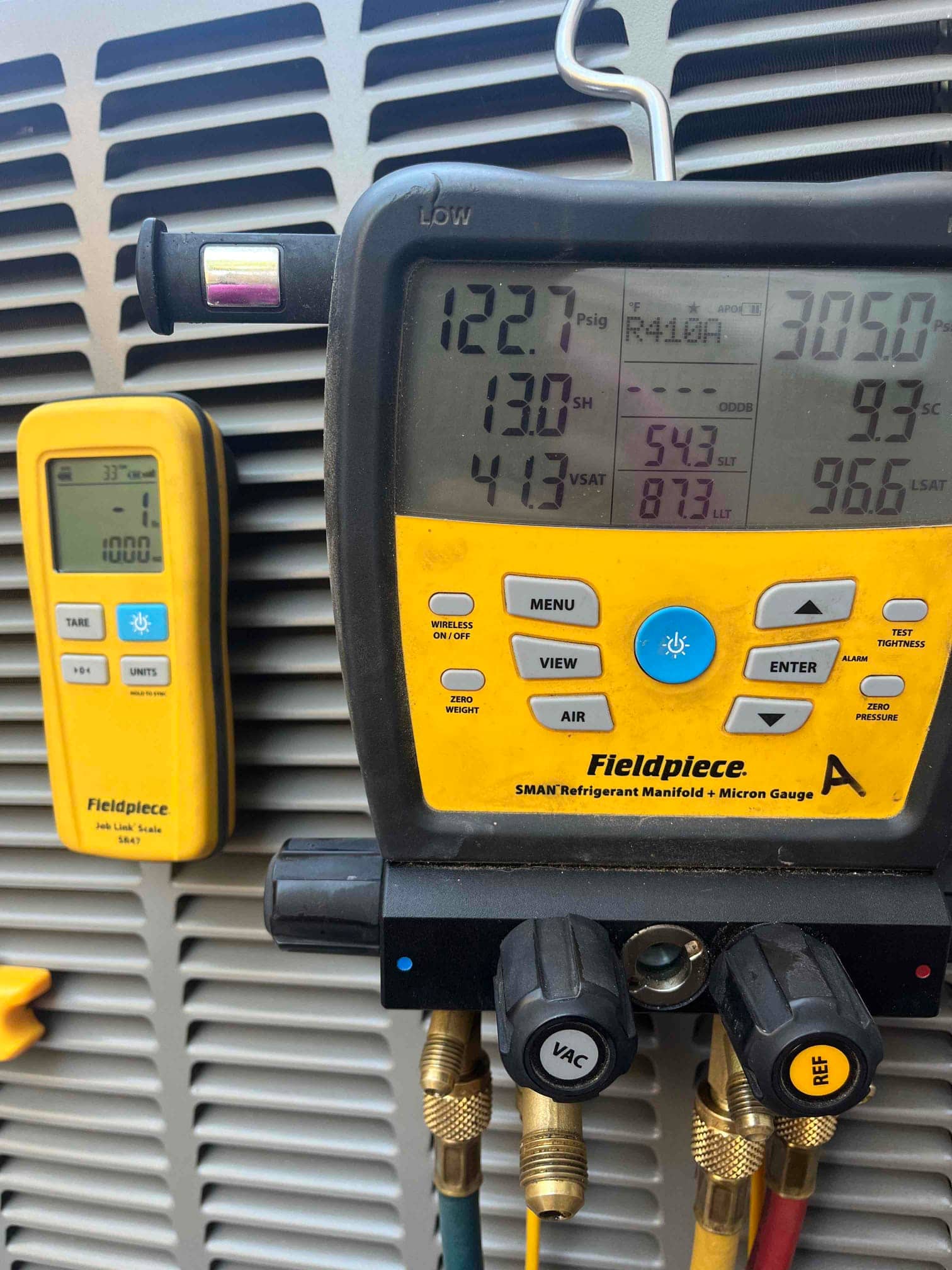 Refrigerant scale photographed during the service visit; no numerical reading is transcribed.