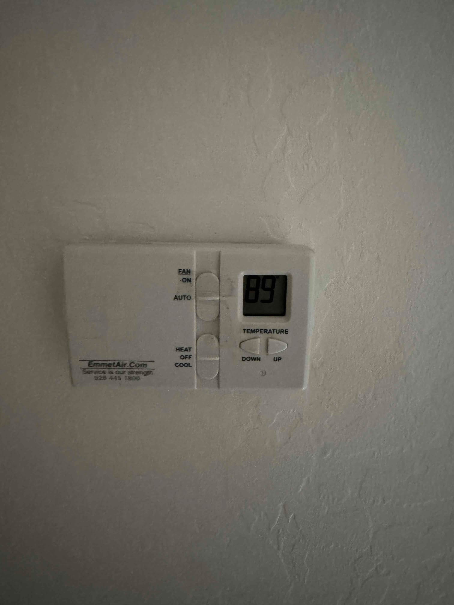 Wall-mounted digital thermostat displays 89 on the screen with fan and system mode switches visible.