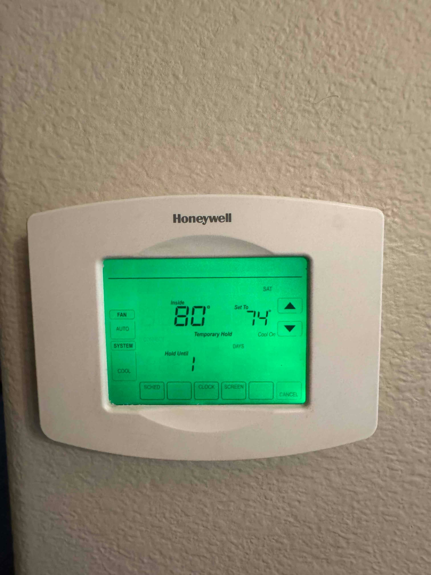 Wall-mounted digital thermostat shows inside 80°F with setpoint 74°F and cooling mode active.