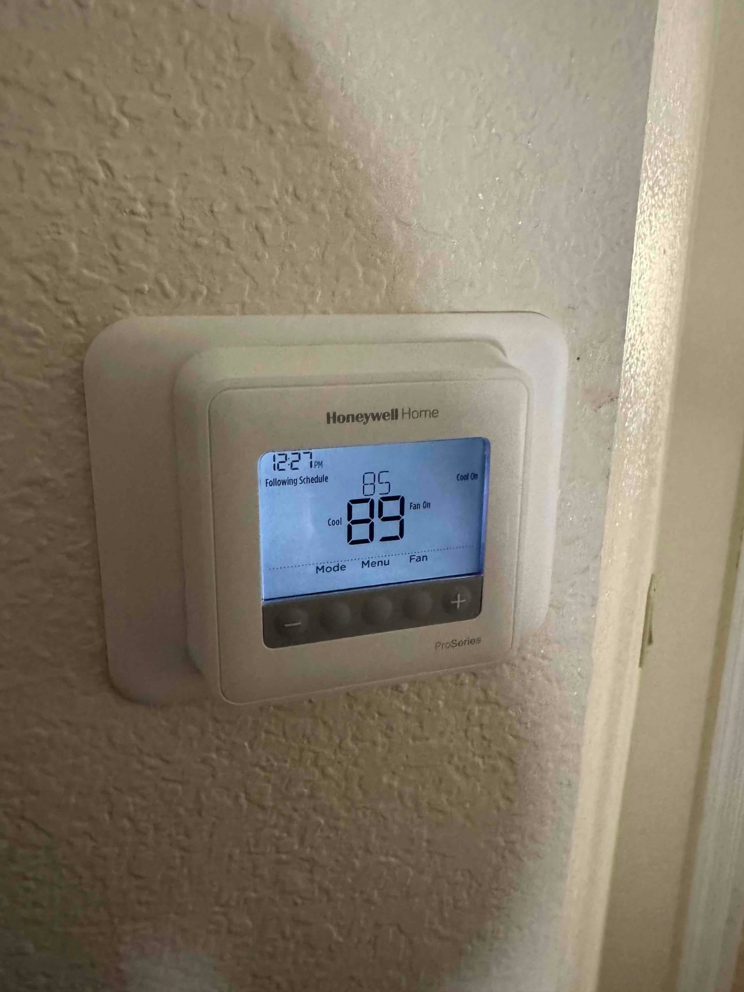 Wall-mounted thermostat display shows 85°F with Cool On indicator and fan on during scheduled operation.