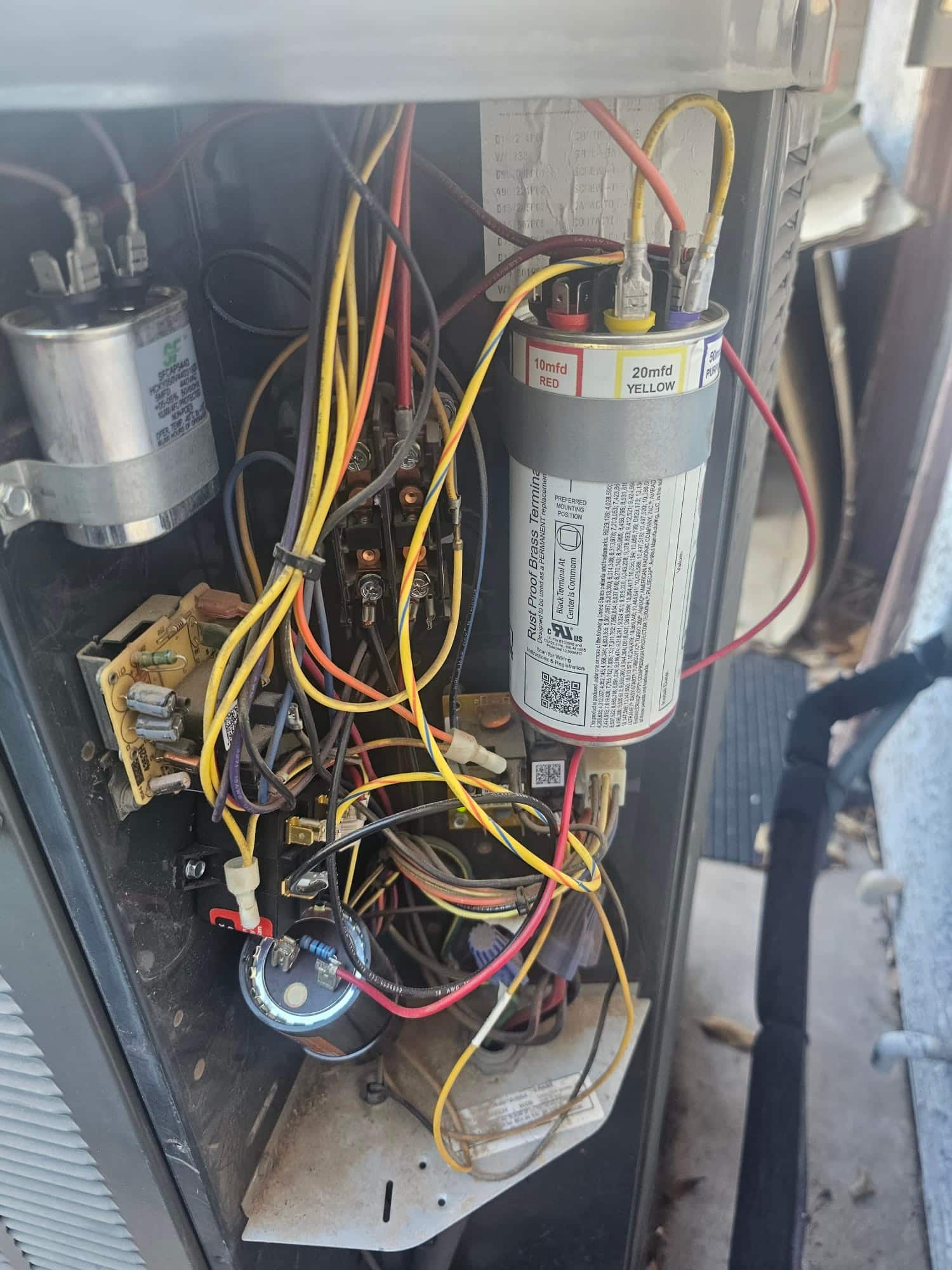 Condenser control compartment with run capacitor labeled 10 mfd RED and 20 mfd YELLOW, wiring attached, contactor and additional capacitors visible.