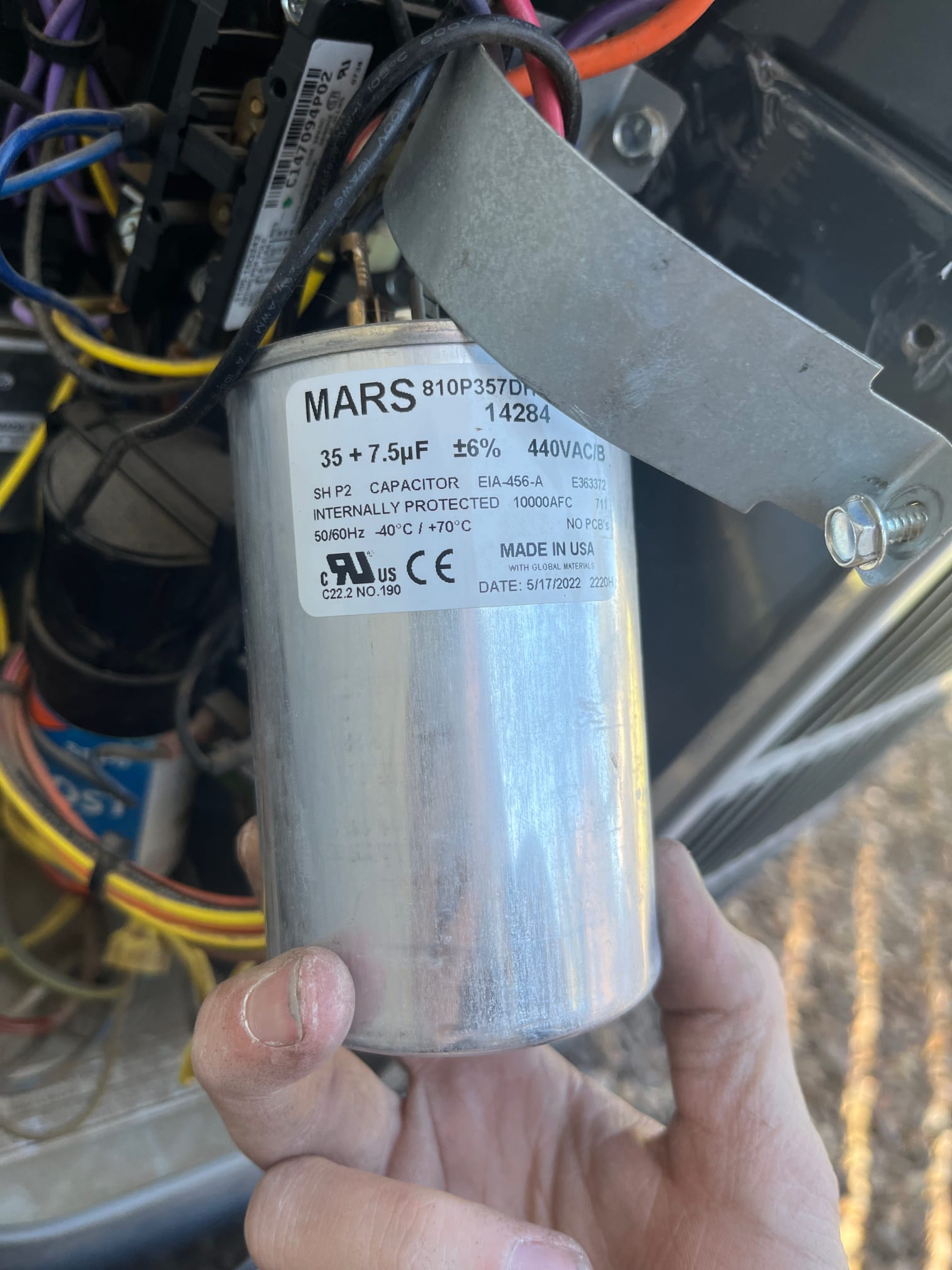 Dual-run capacitor labeled 35 + 7.5 μF ±6% 440VAC, installed in the condenser cabinet with wiring connected and mounting strap.