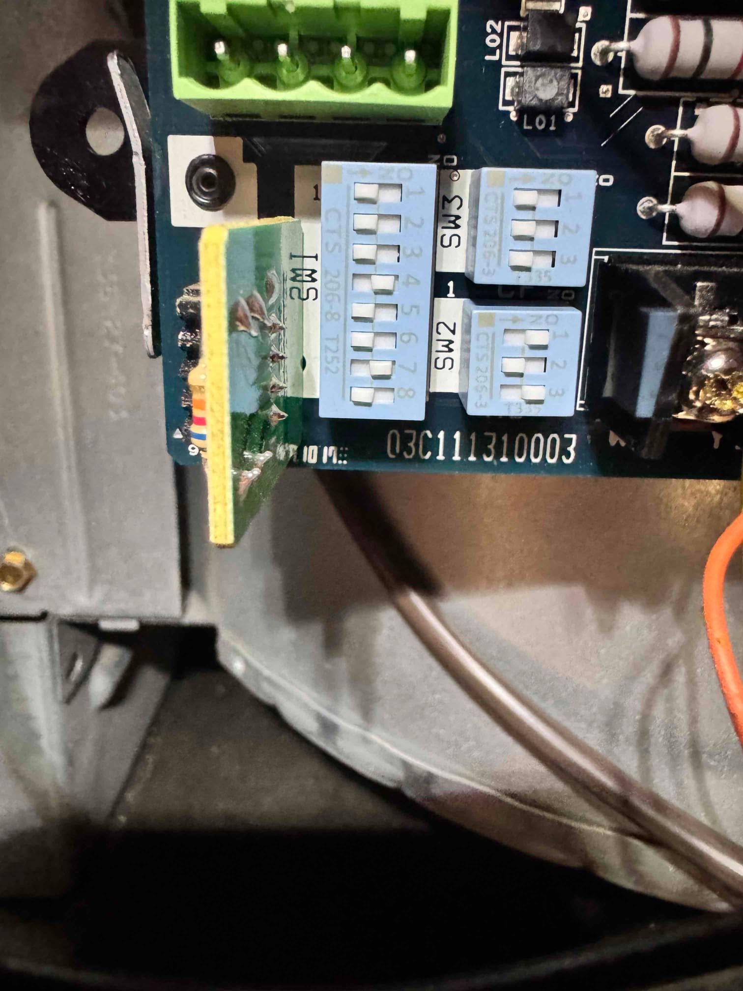 HVAC control board inside the cabinet showing DIP switches SW2 and SW3 and green terminal block.