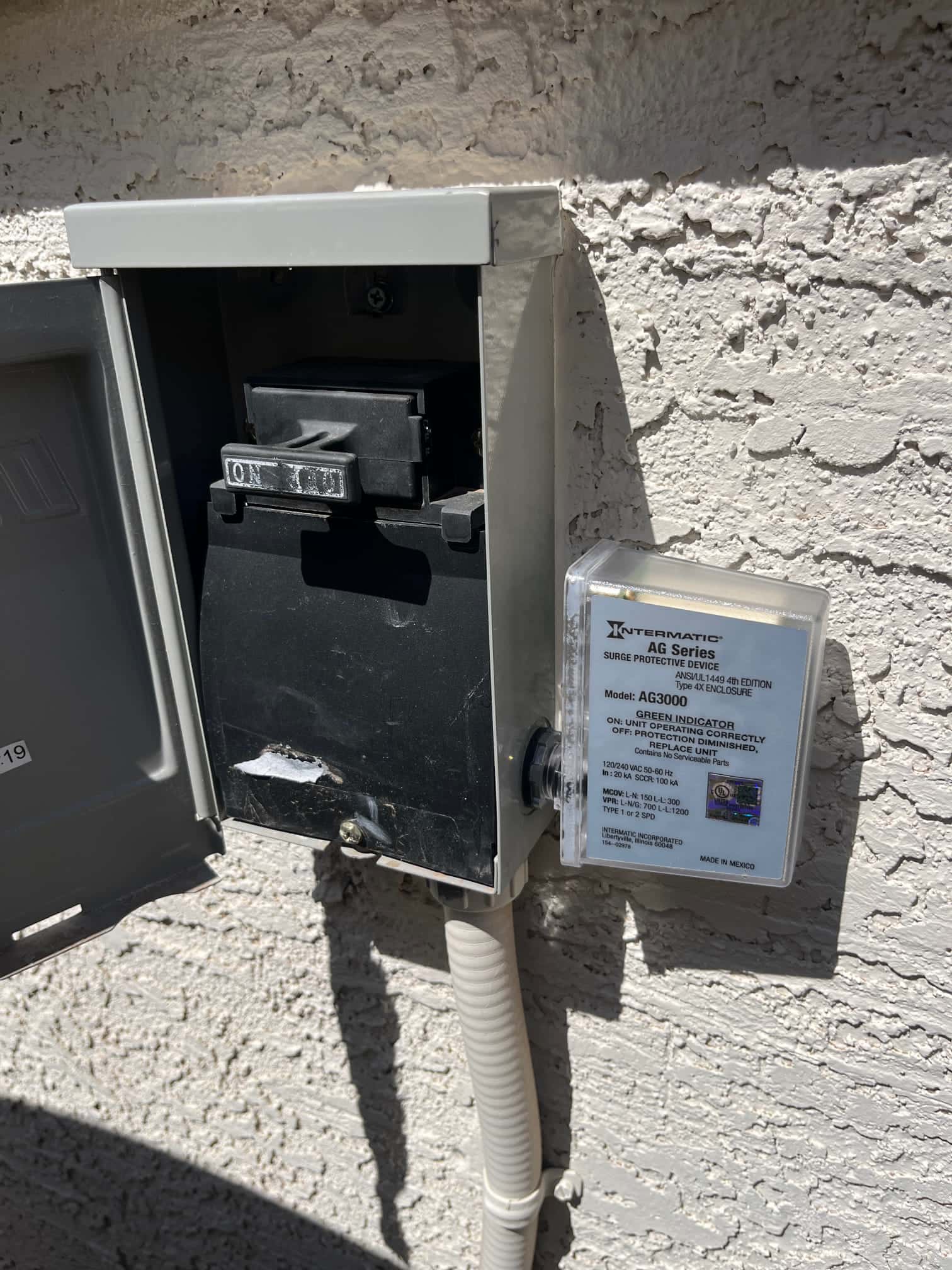 Outdoor disconnect with pull-out switch in ON position and surge protective device mounted beside conduit.