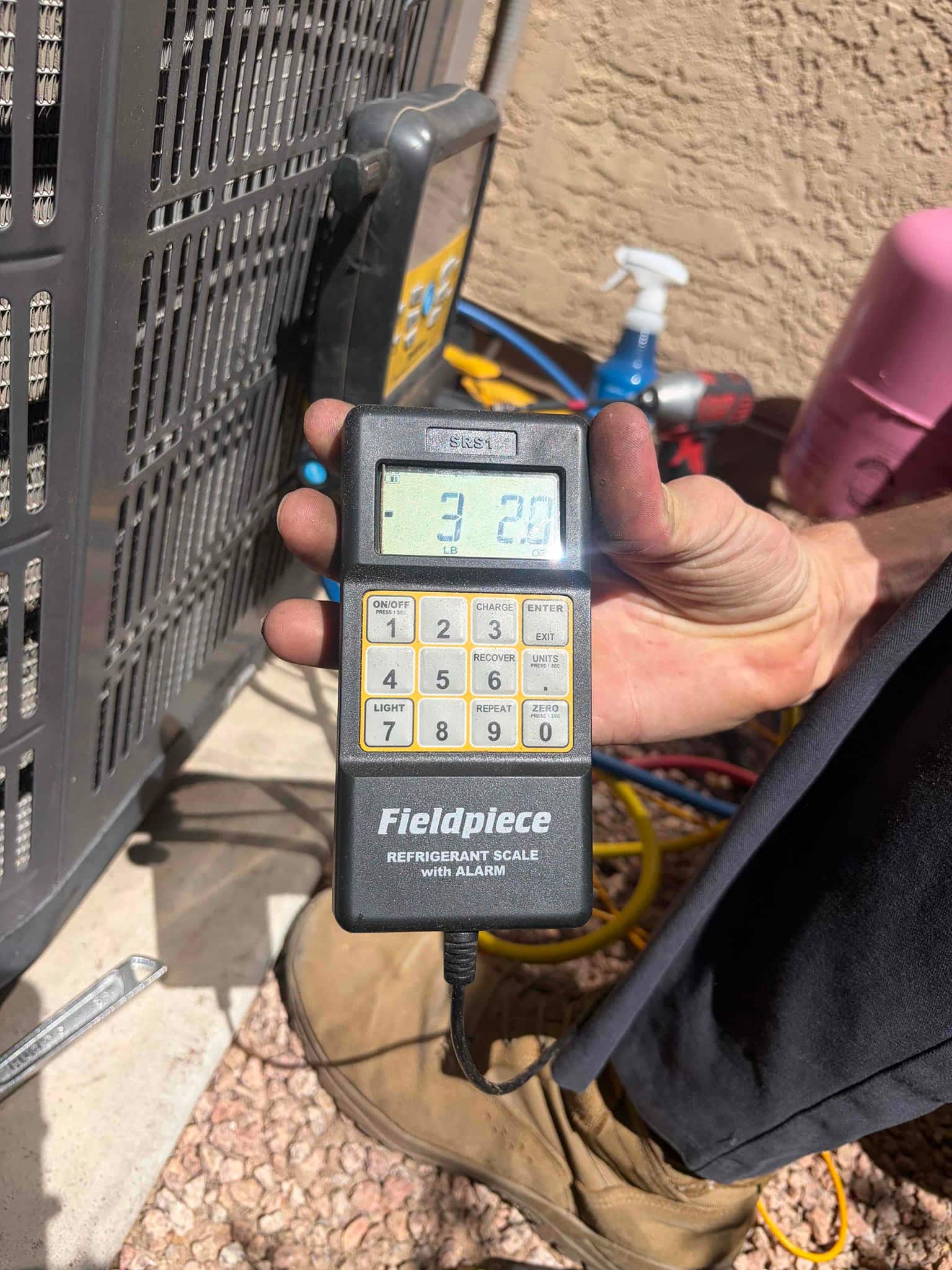 Refrigerant scale photographed during the service visit; no numerical reading is transcribed.