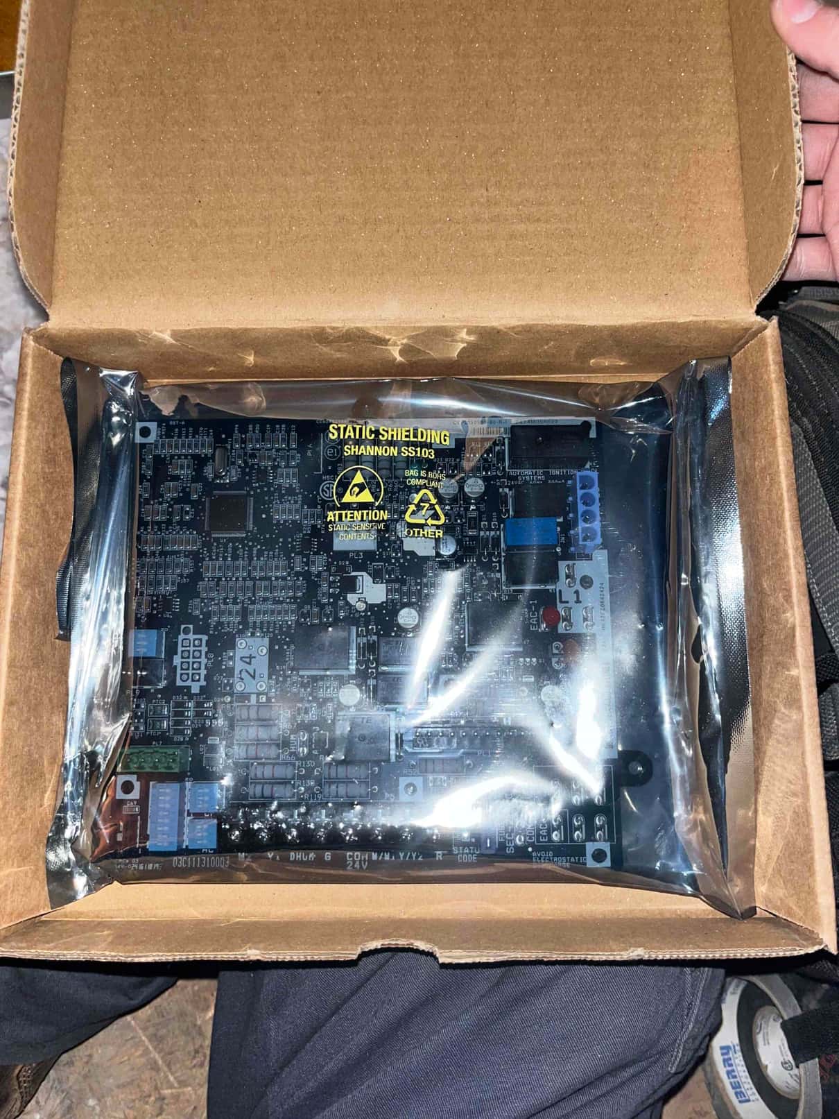 Replacement control board sealed in an antistatic bag inside a cardboard box during service visit.