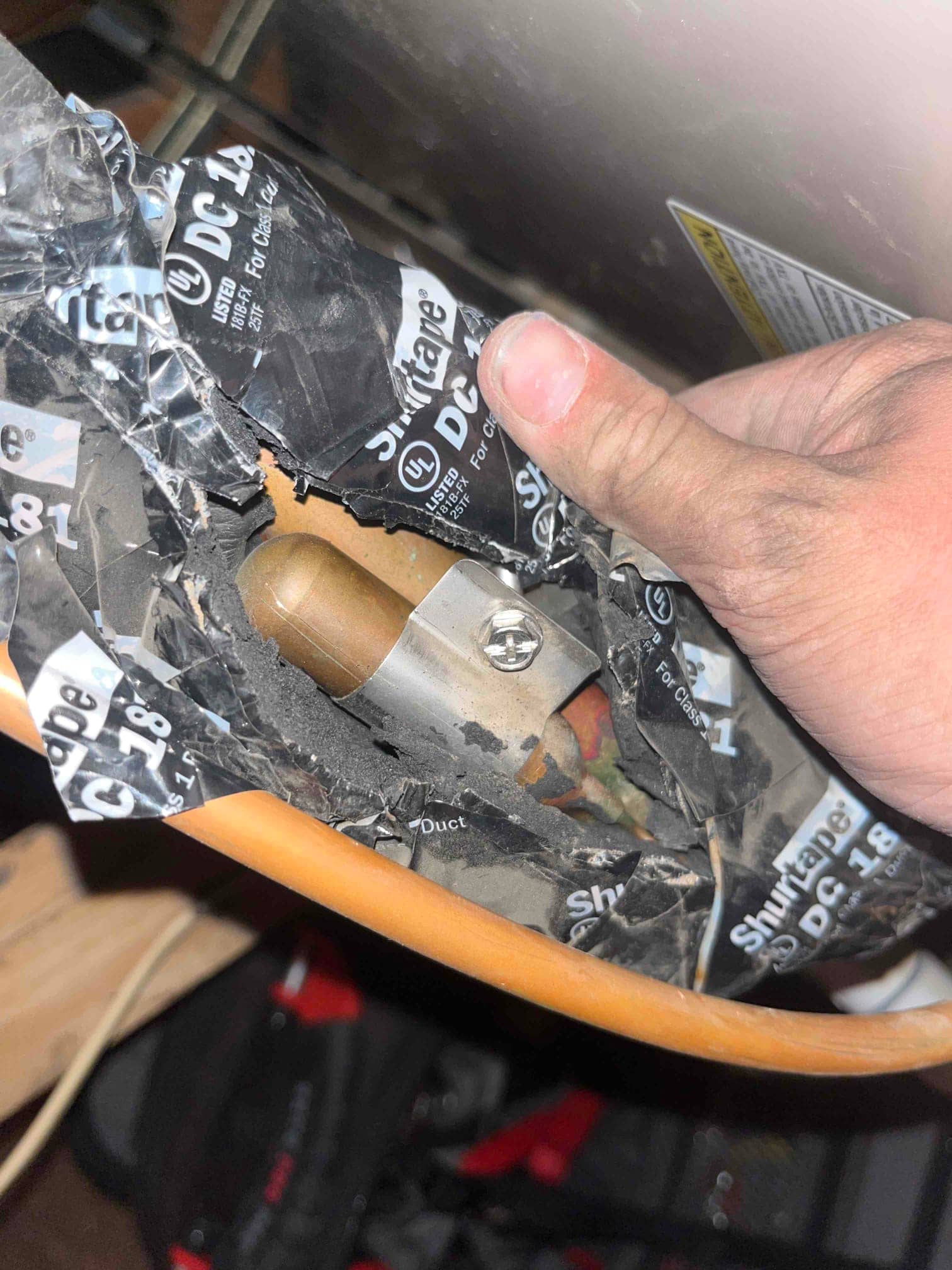 Thermostatic expansion valve sensing bulb clamped to suction line, insulation peeled back and secured with tape.