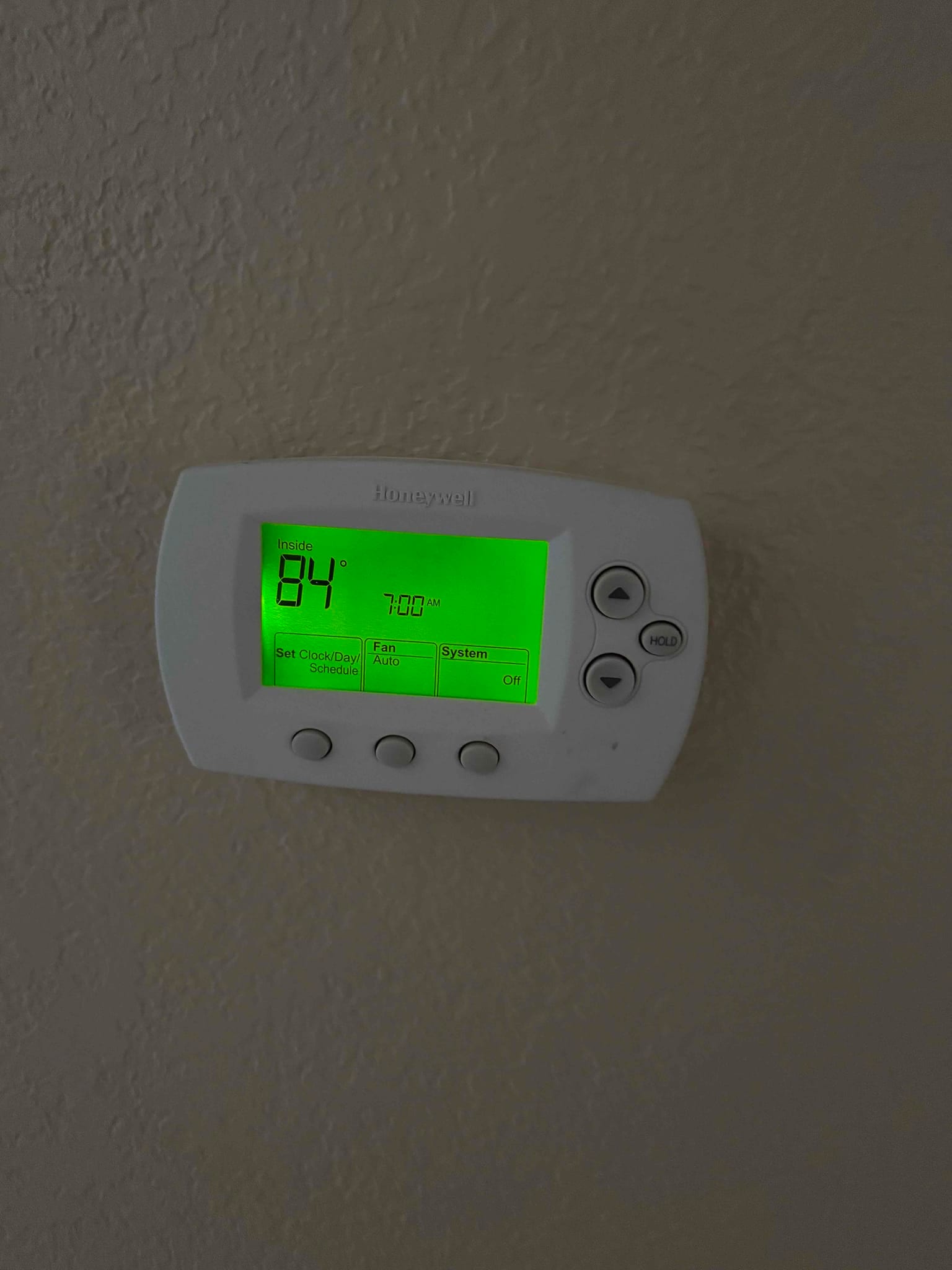 Wall-mounted thermostat display shows inside temperature 84° with fan set to Auto and system Off.