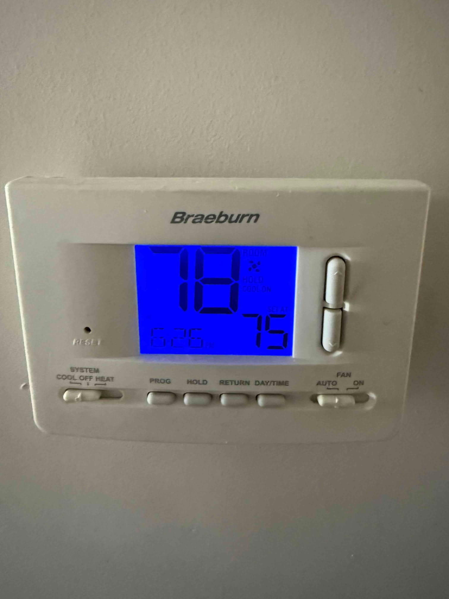 Digital thermostat on wall showing 78°F room temperature and 75°F setpoint, cooling mode selected with fan on auto.