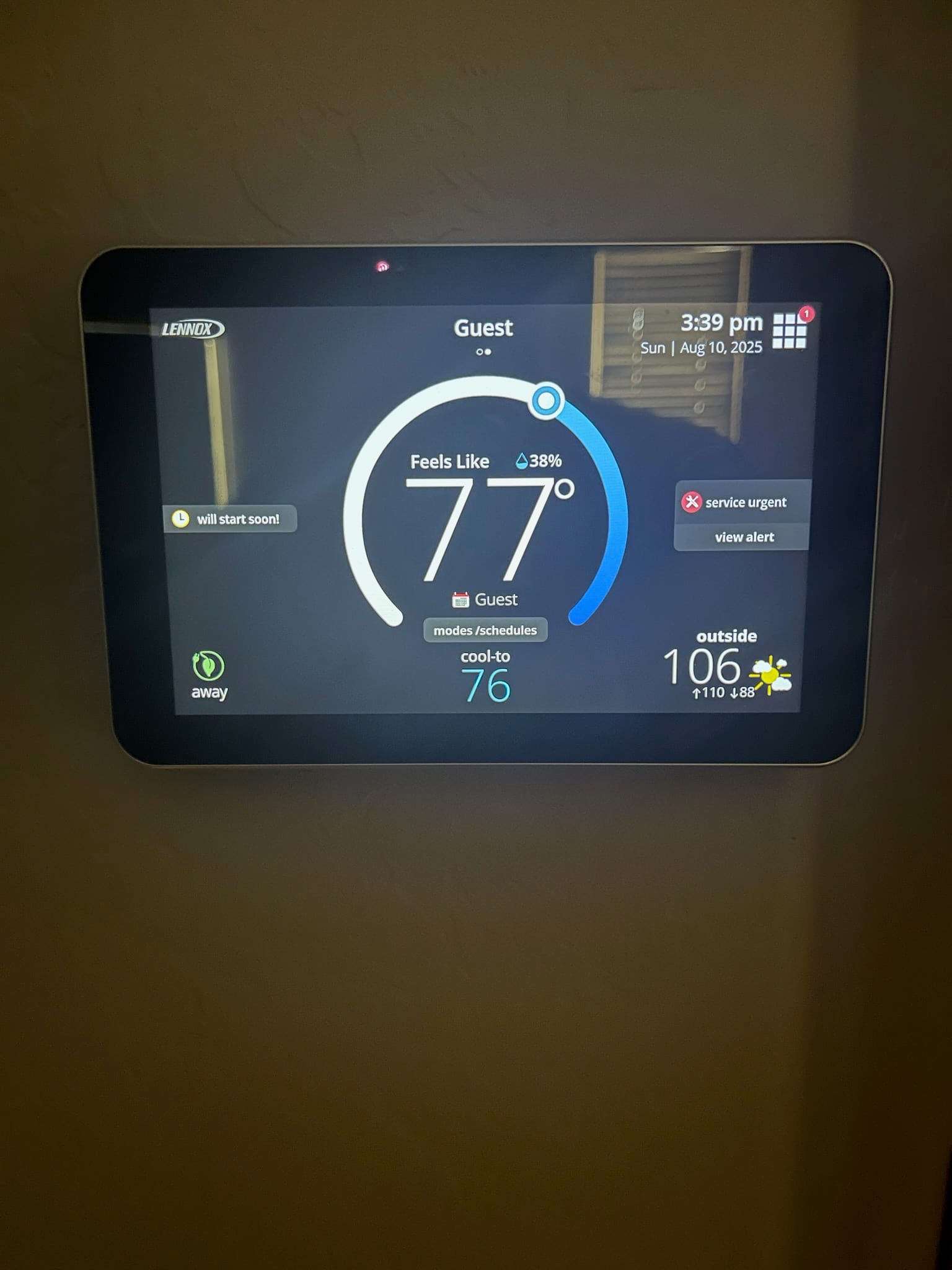 Wall-mounted thermostat touchscreen shows indoor Feels Like 77 with cool-to setpoint 76 and outside temperature display.