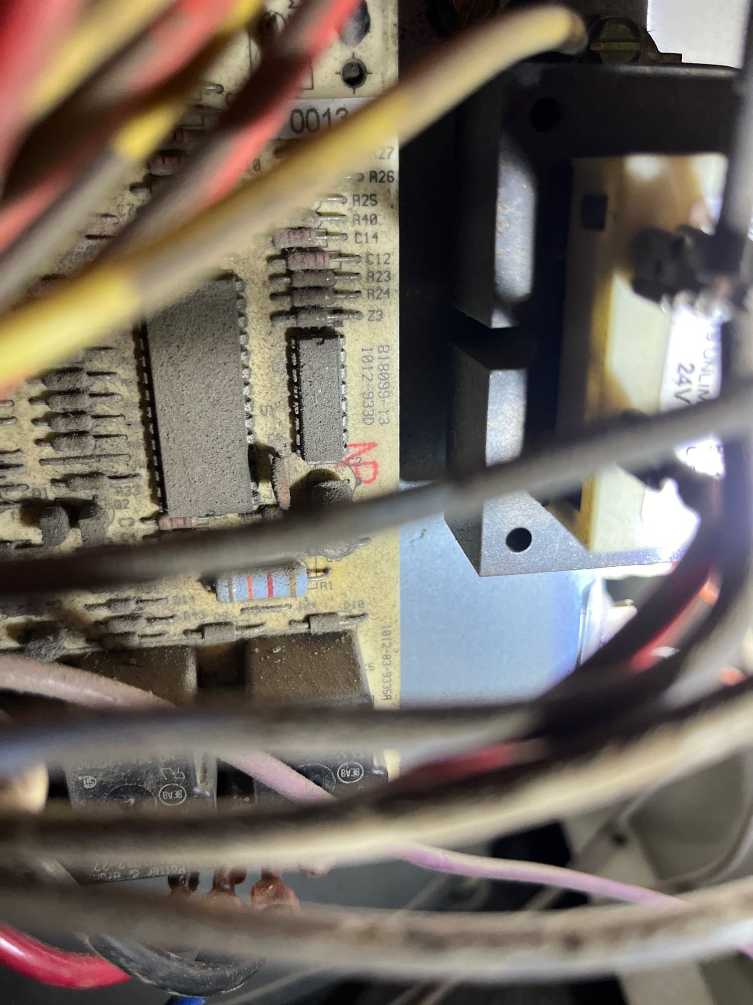 Close-up of control board inside the unit, with multiple wires and dusty components including a labeled resistor R1.
