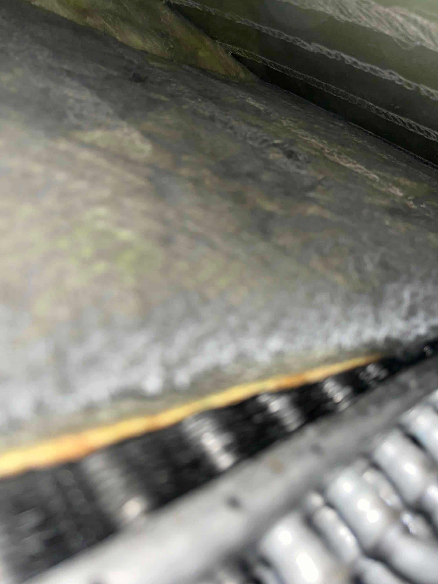 Close-up view shows evaporator coil tubing and fins beneath surrounding insulation inside the indoor air handler cabinet.