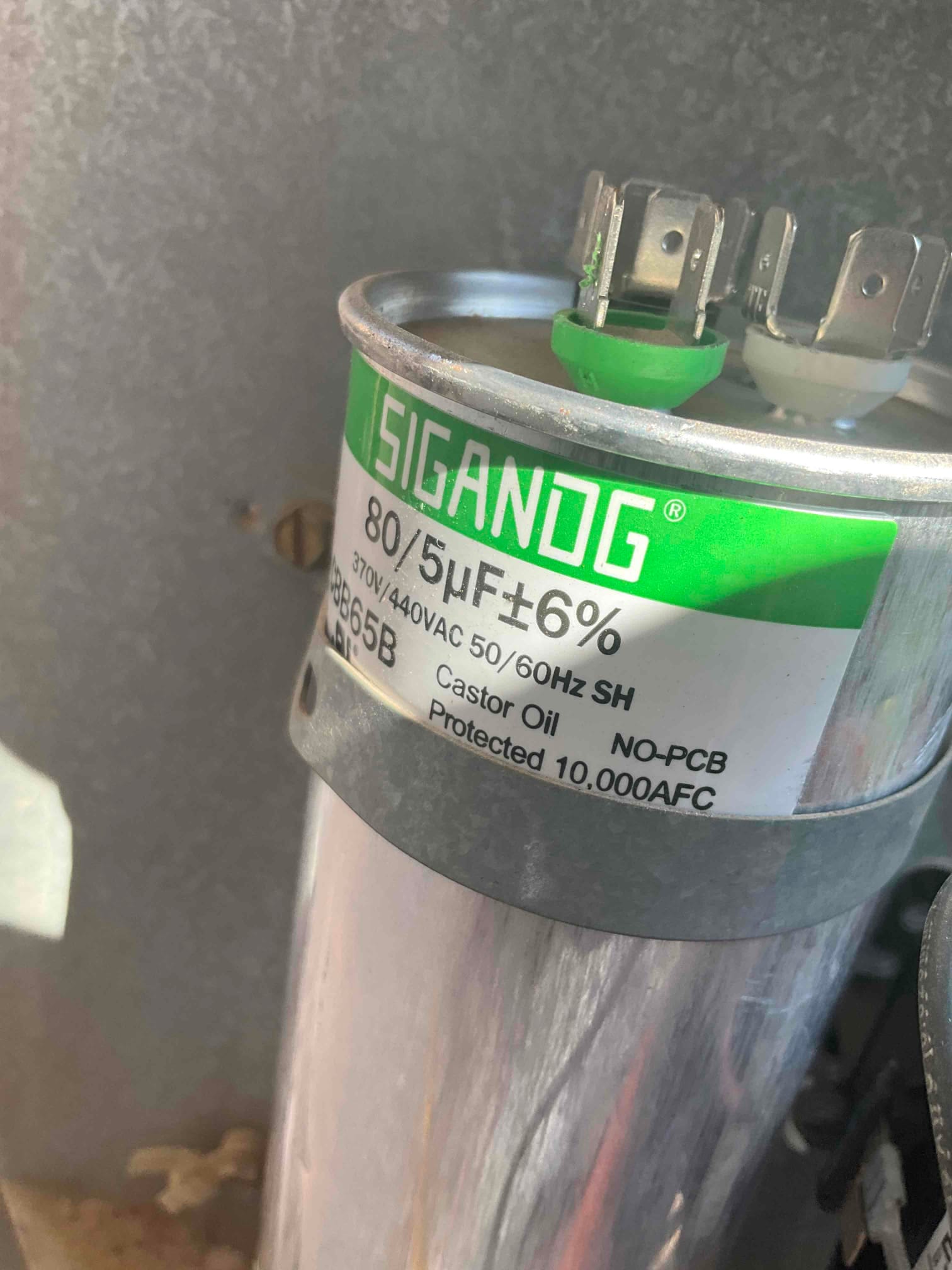 Dual-run capacitor labeled 80/5 μF ±6% and 370V/440VAC, with metal can body and top wiring terminals visible.